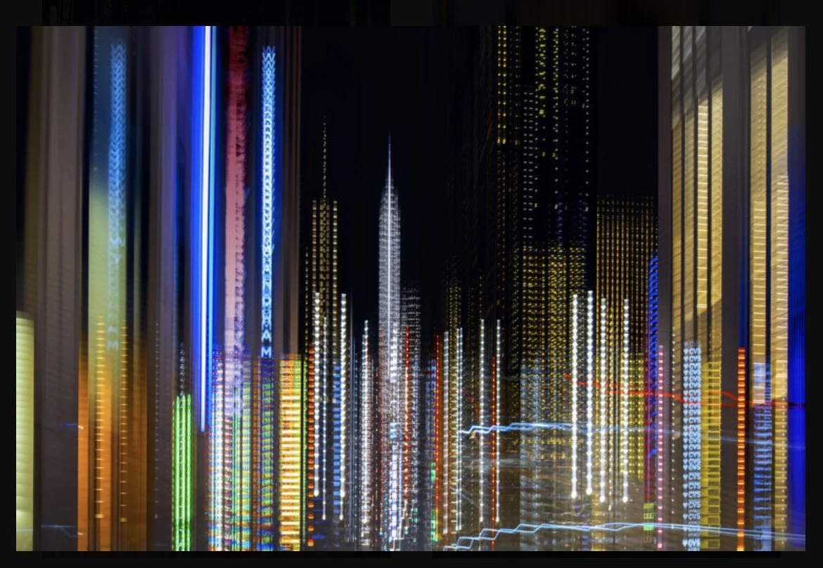 Abstract cityscape with blurred lights and skyscrapers at night, showcasing vibrant colors and vertical lines.