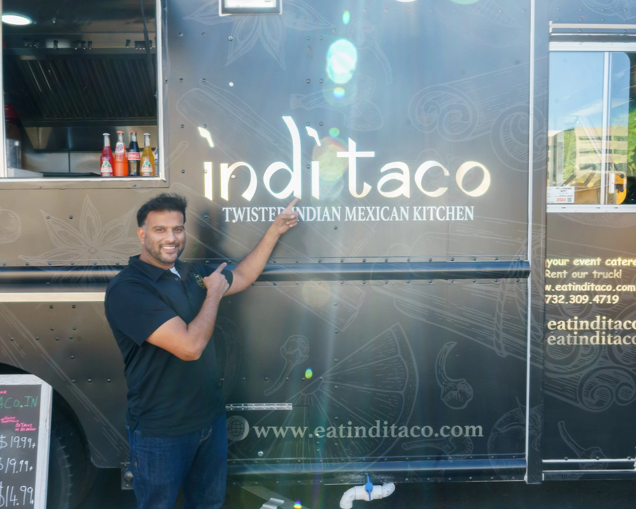 Person pointing at food truck with "IndiTaco" logo