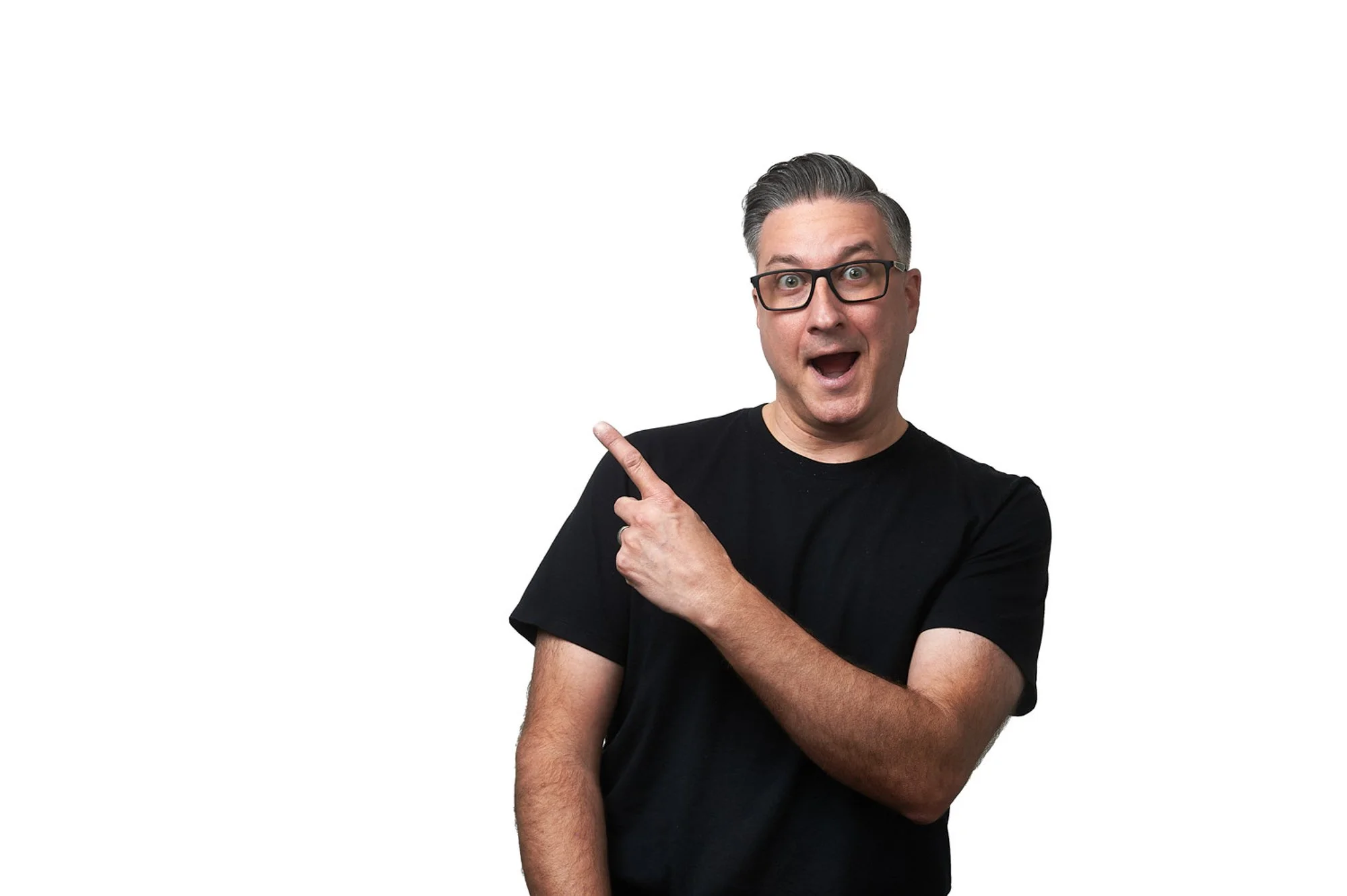 Man wearing glasses and a black shirt pointing and smiling against a white background.