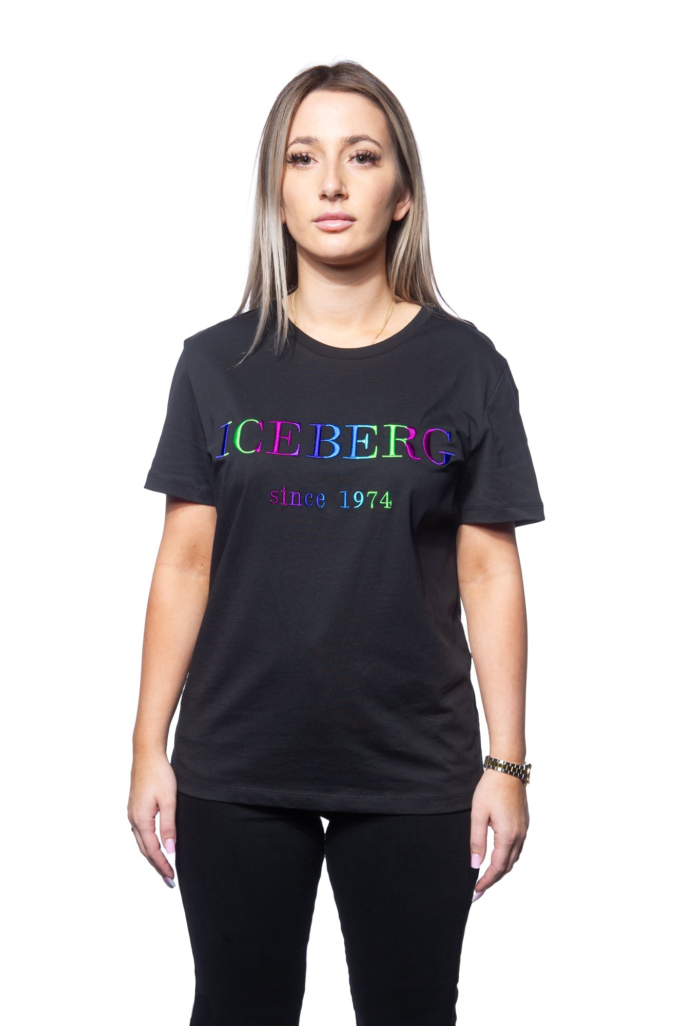 Person wearing a black T-shirt with "ICEBERG since 1974" printed in colorful letters.