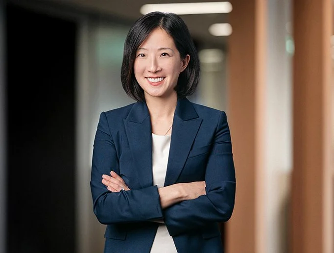 A photo of an Asian women in a dark blue jacket