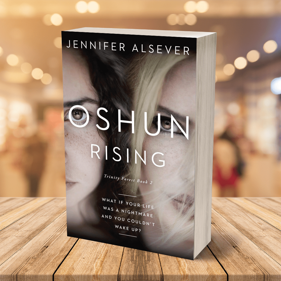 A paperback book titled 'Oshun Rising' by Jennifer Alsever, featuring a cover image of two women's faces, one with dark hair and one with light hair, with a background of soft, blurred warm lights.
