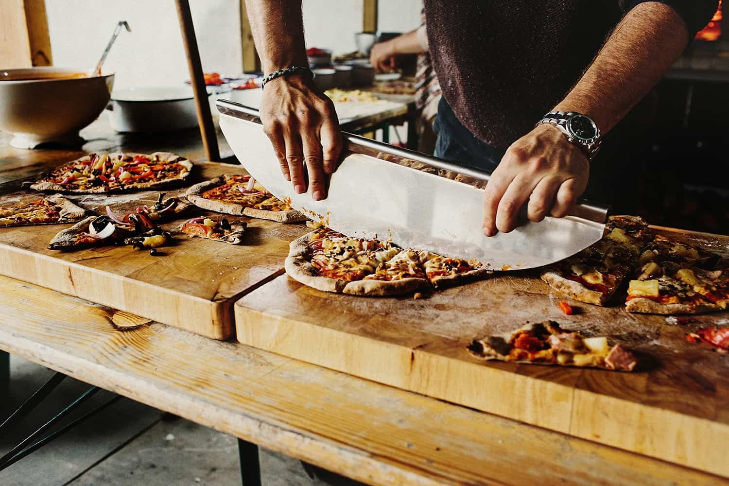 man cutting pizza