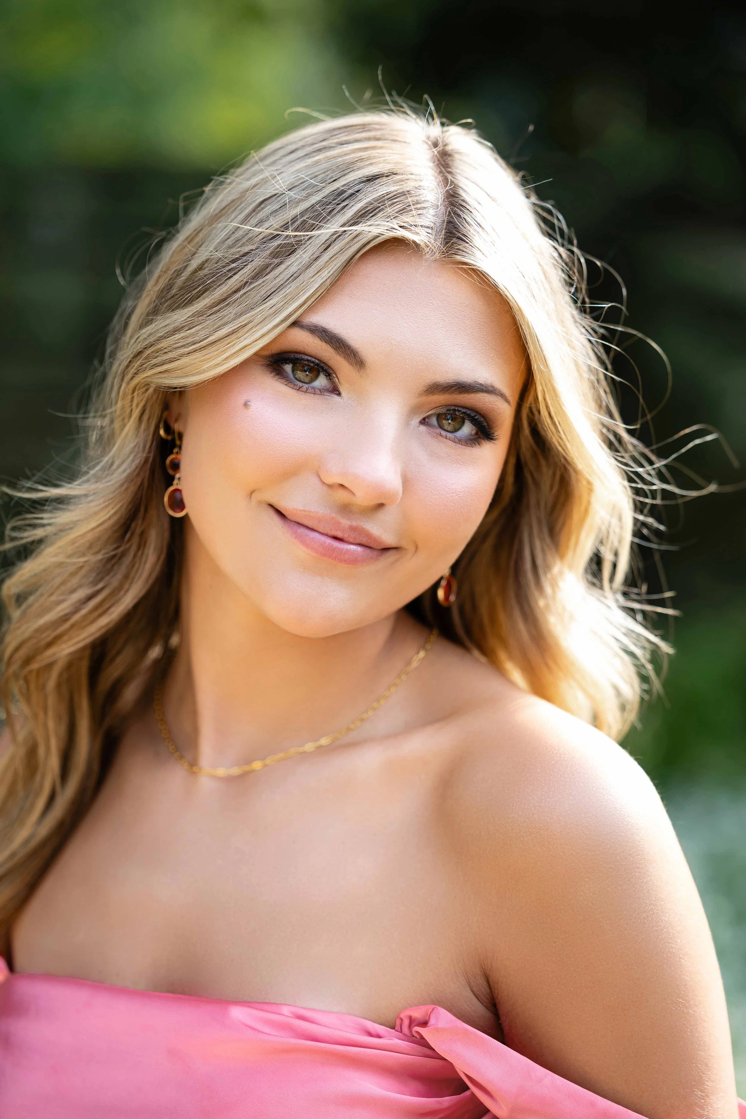 senior photo of girl in pink dress