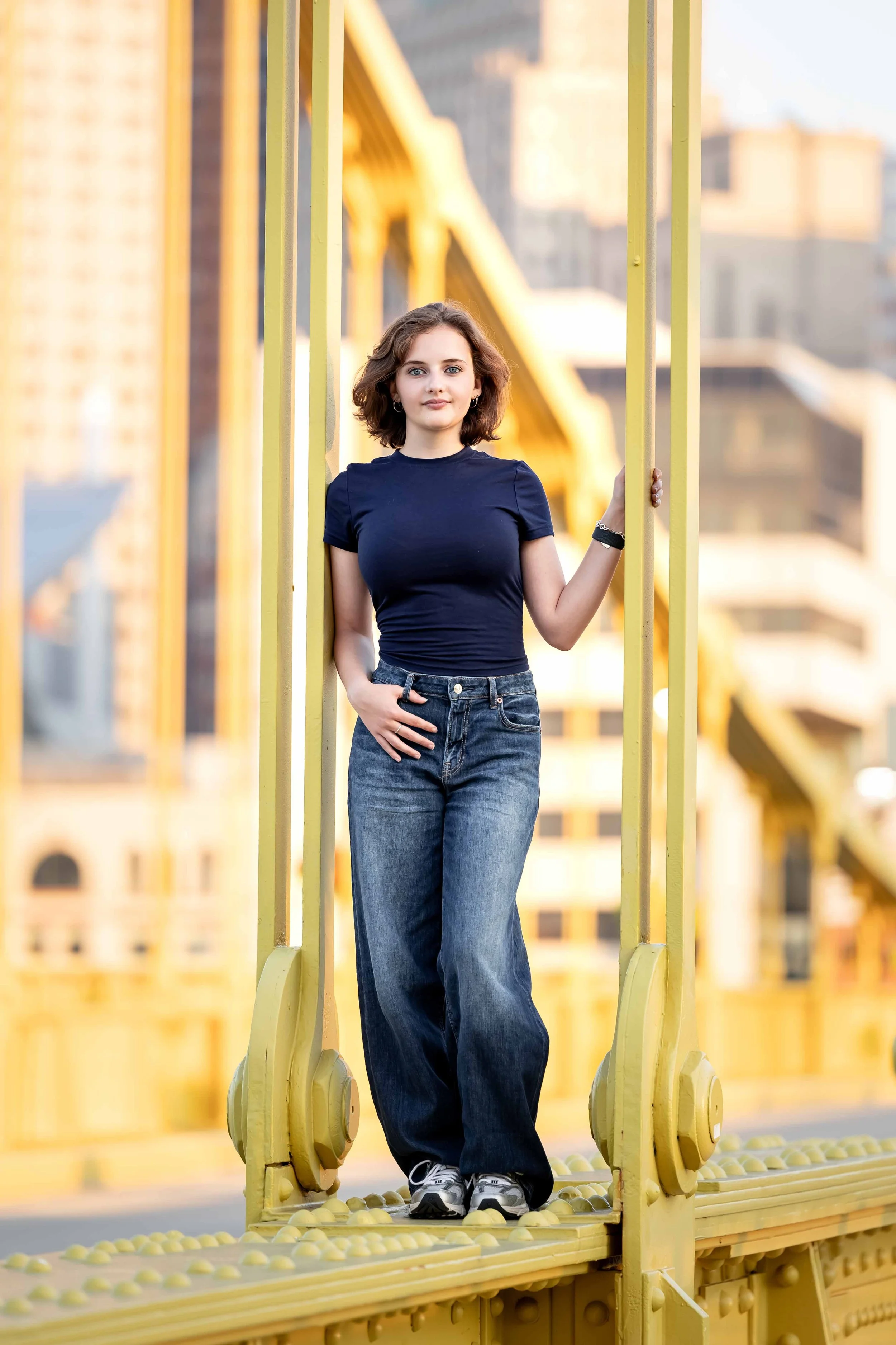 girl posing on yellow bridge in Pittsburgh