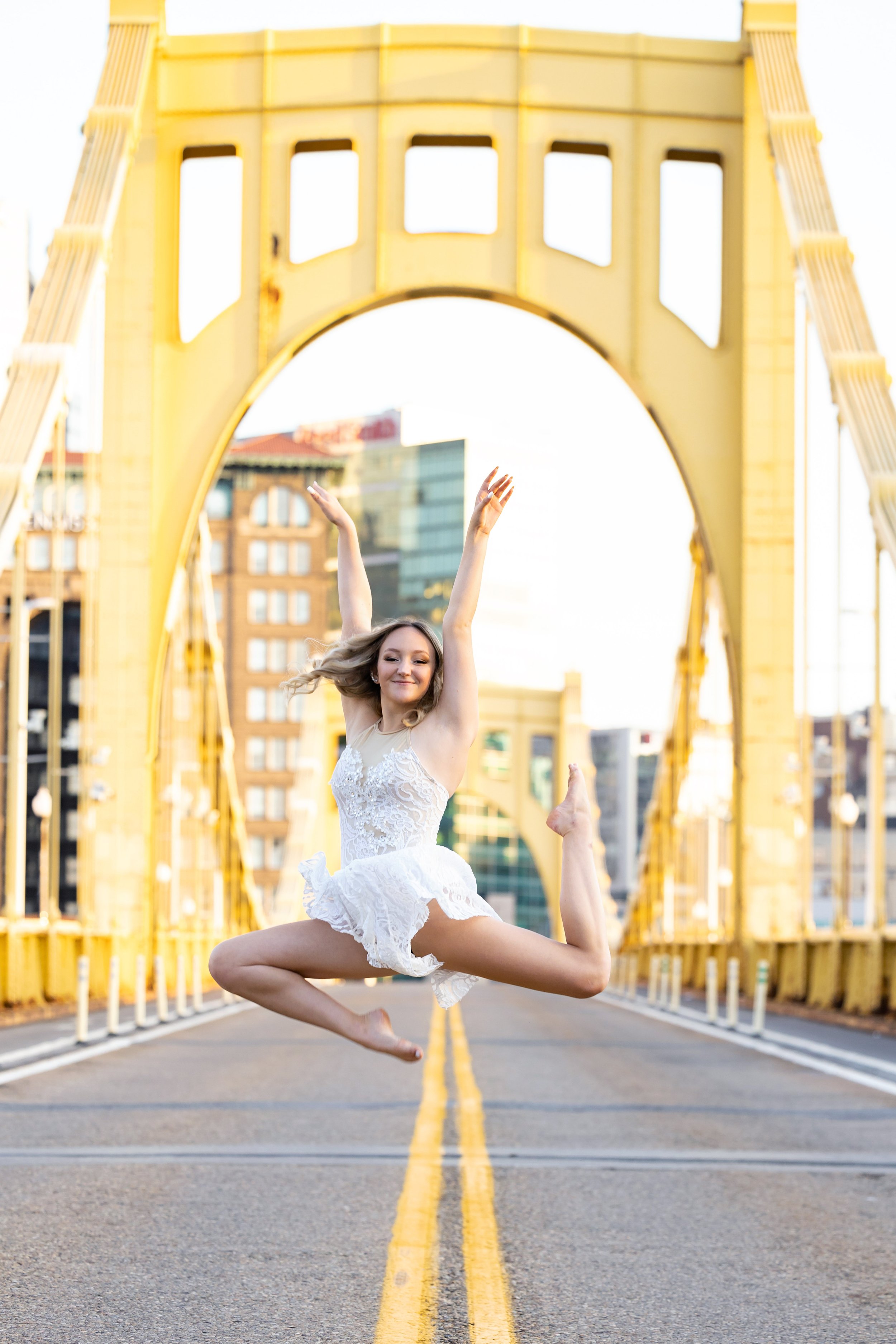 senior photo of dancer pose on yellow bridge Clemente Bridge Pittsburgh