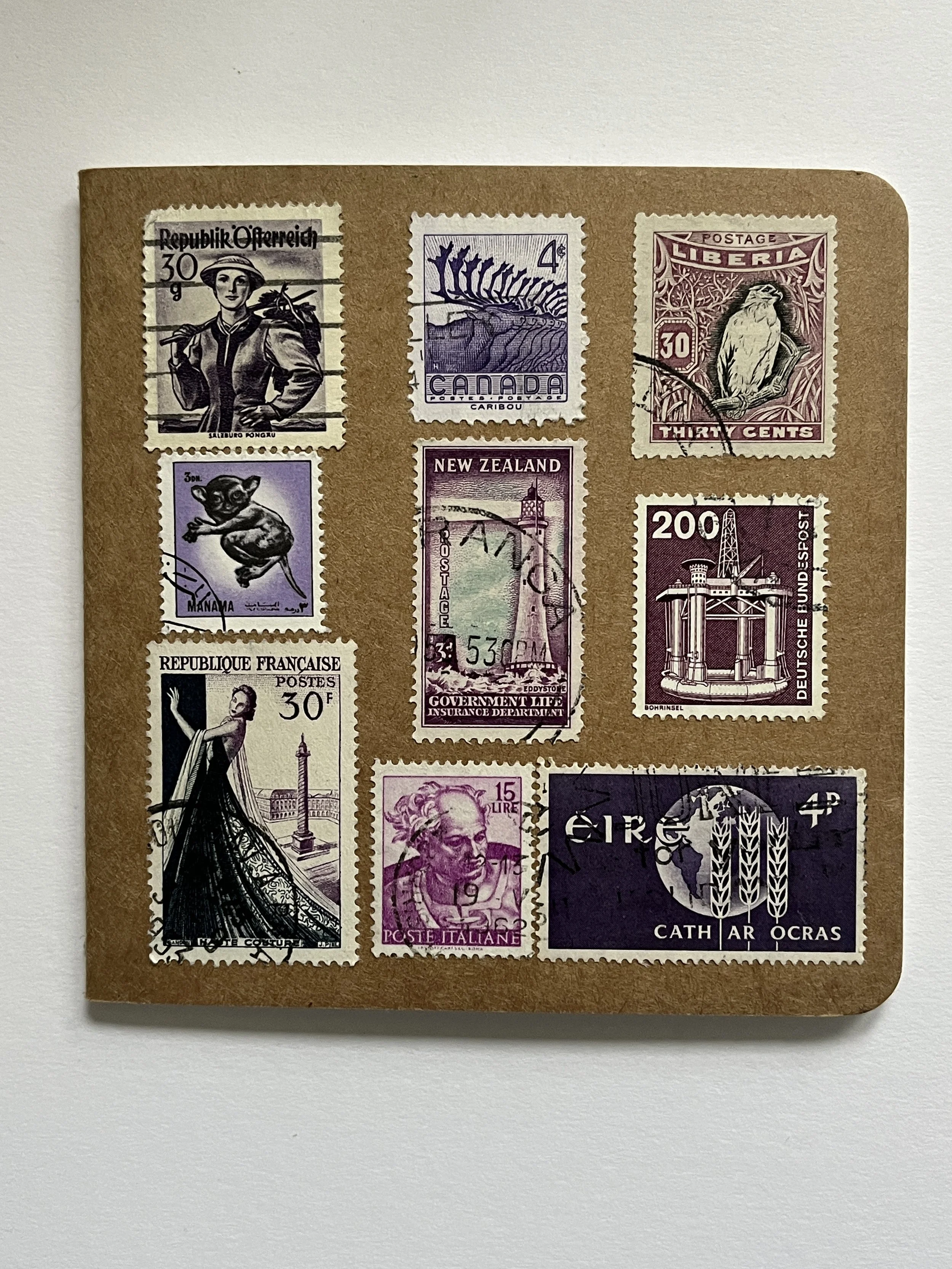 pink purple toned stamps, a notebook covered with worldwide stamps
