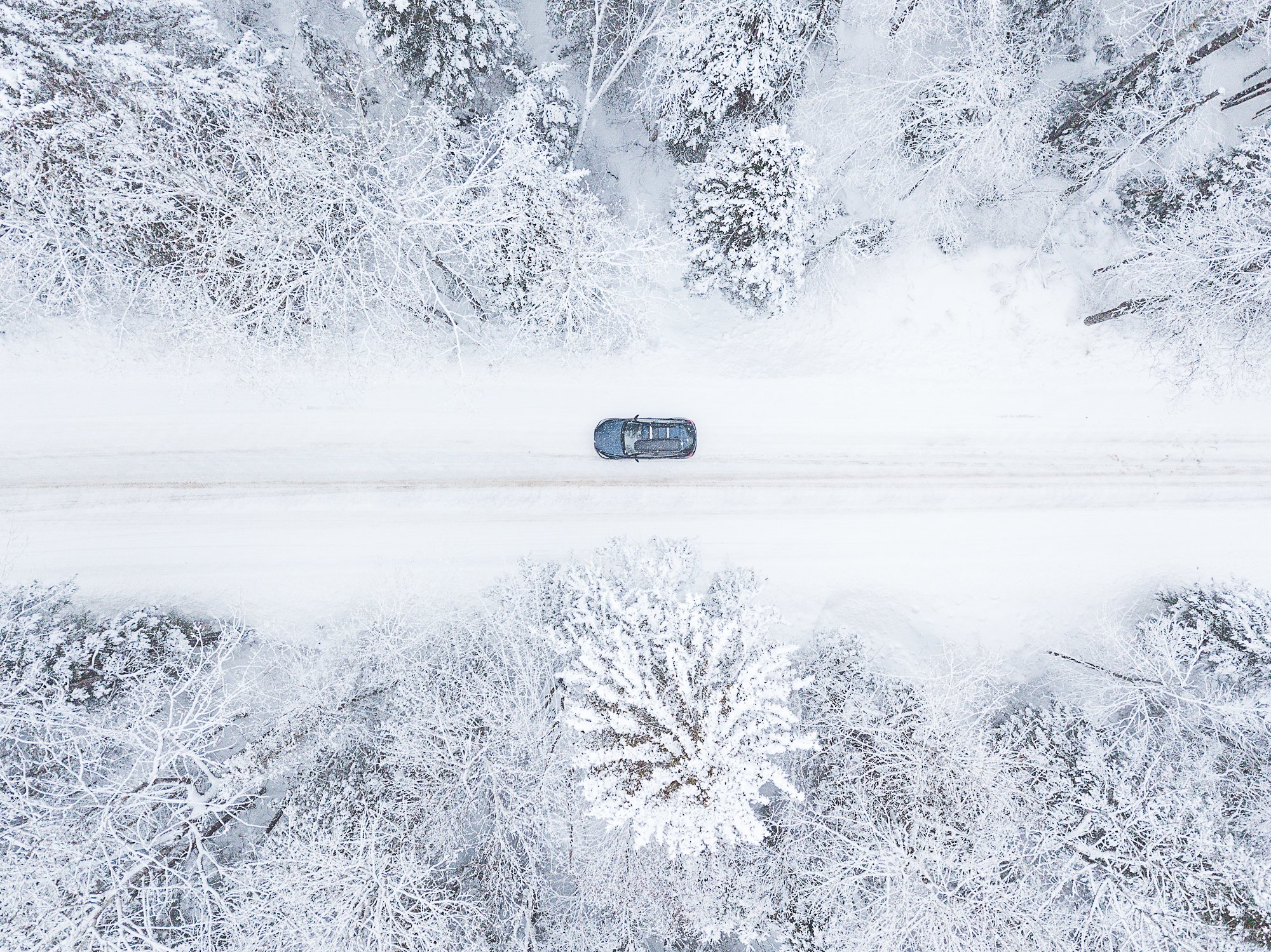 A Mazda 3 drives along a snow-covered back road in winter_.jpg