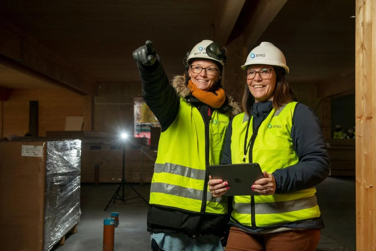 2 women with helmet and safety vest working for Xpro