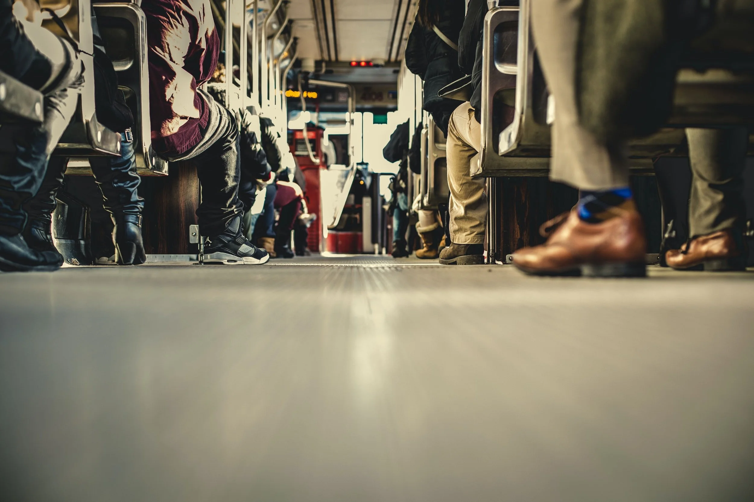 Føter av folk som sitter på i bussen