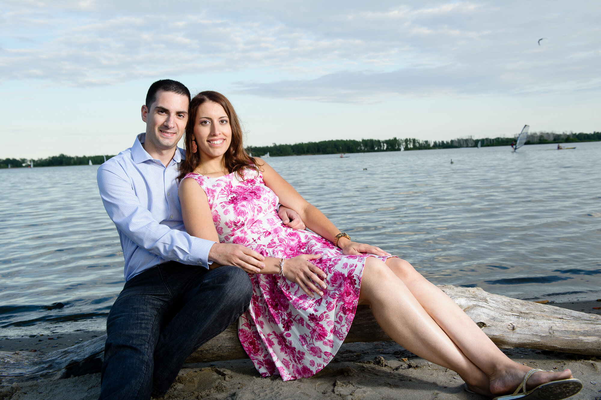 Couple sitting on driftwood by a lake