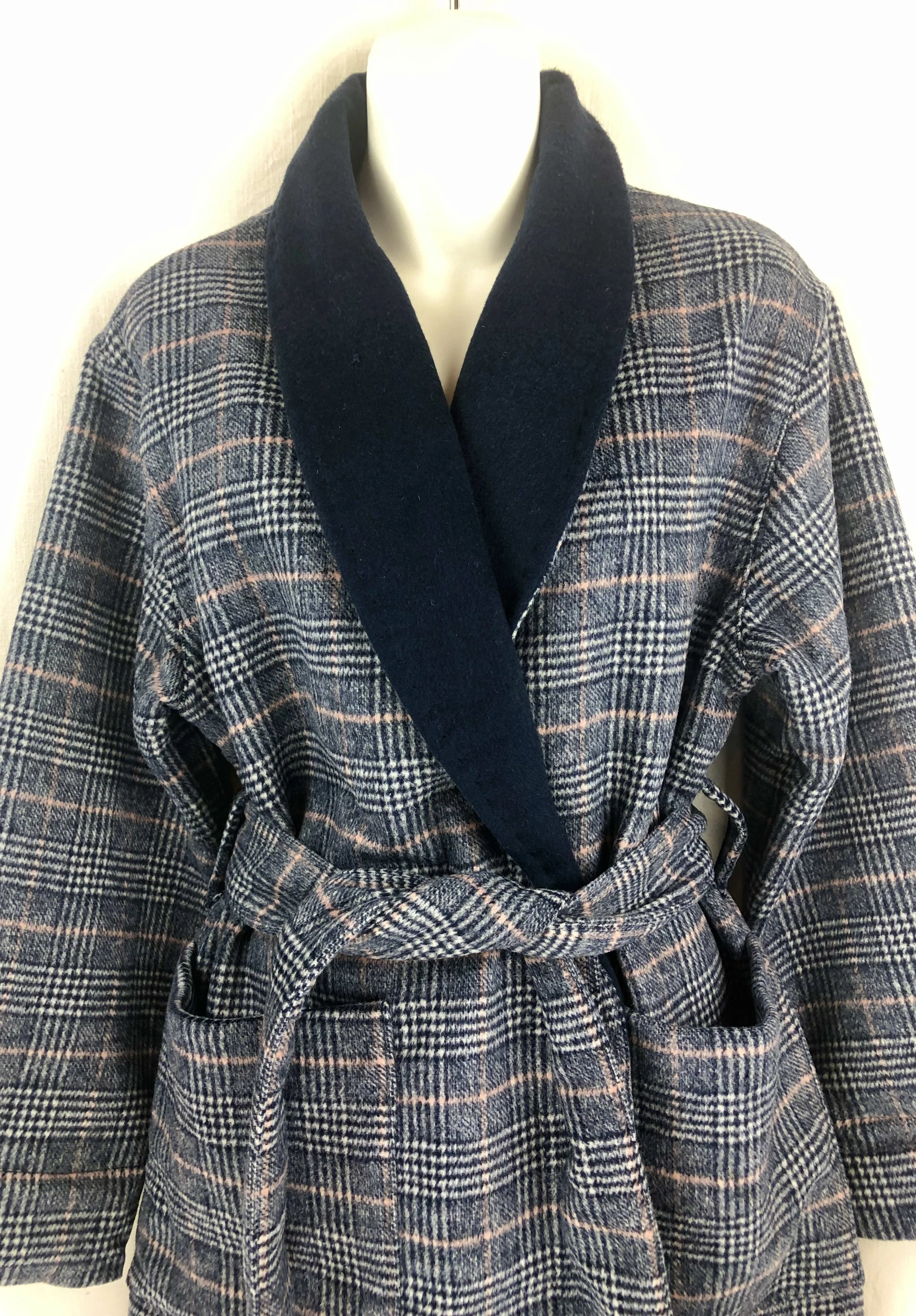 A mannequin wearing a handmade wool dressing gown with a black shawl collar and a matching belt tied at the waist.