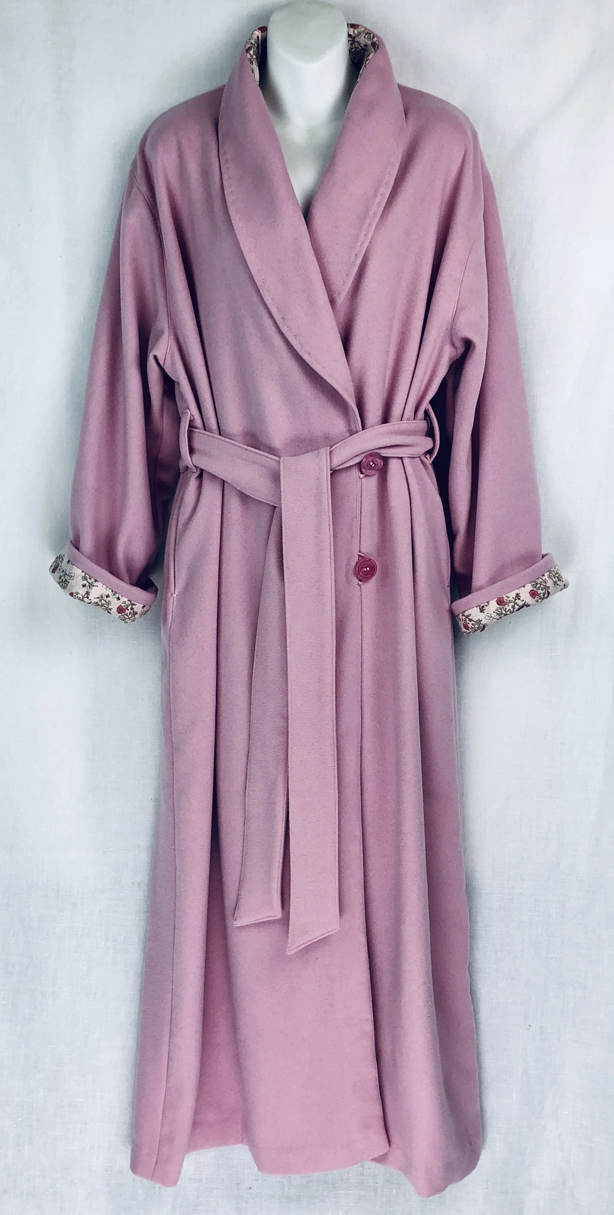 Pink long Italian wool dressing robe with floral-lined cuffs and a matching belt, buttoned in the middle.