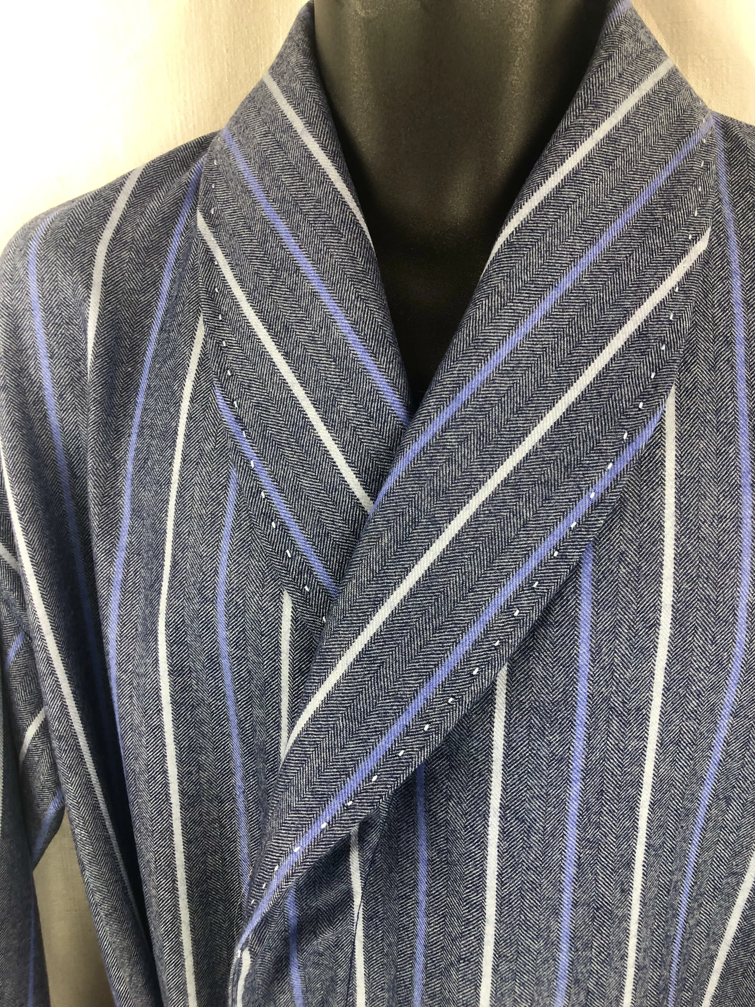 Close-up of a men's dressing robe with a blue and gray striped pattern on a mannequin.