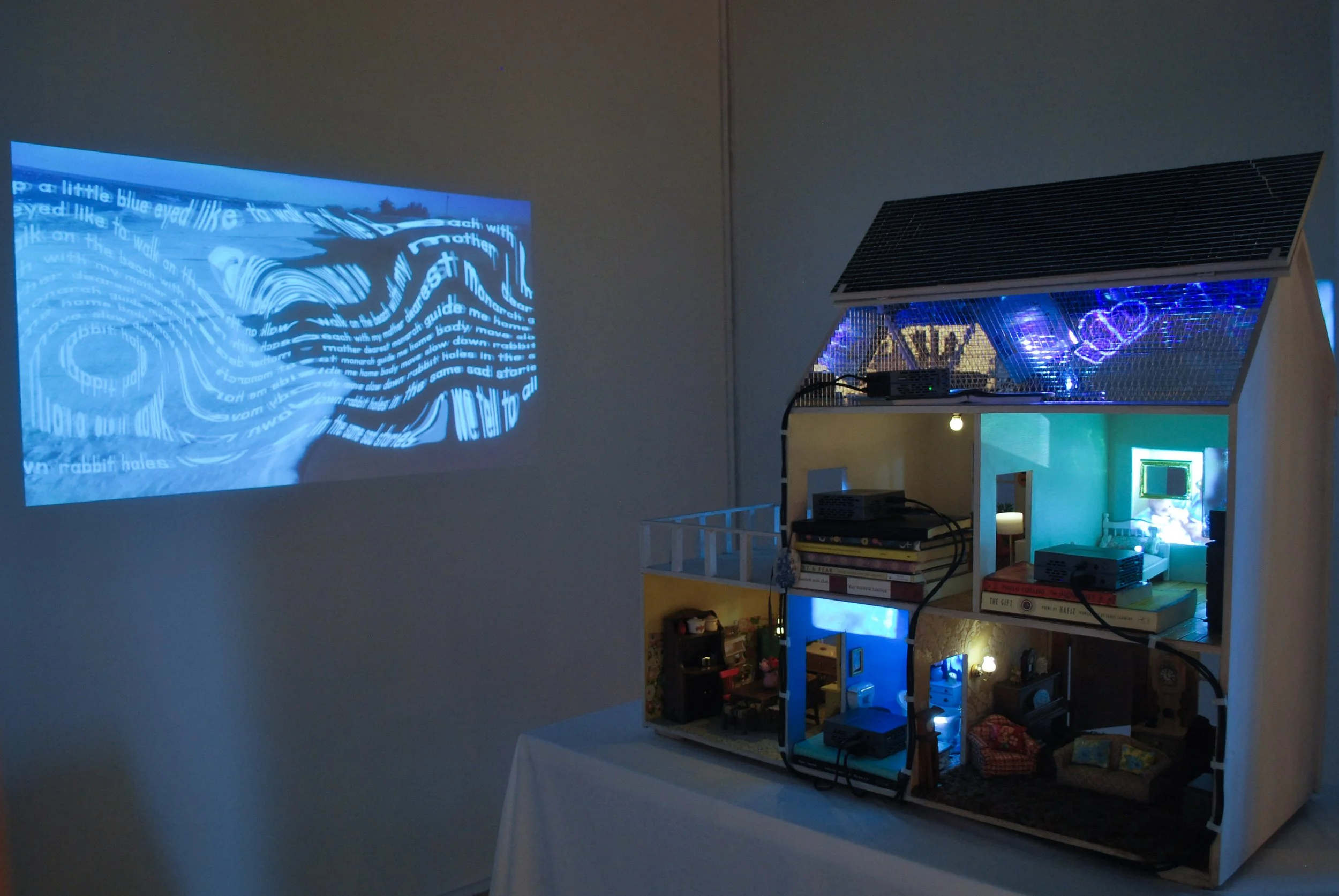 Multimedia installation infinitlovalie by Lauren Be Dear featuring altered dollhouse projections and family archive footage.