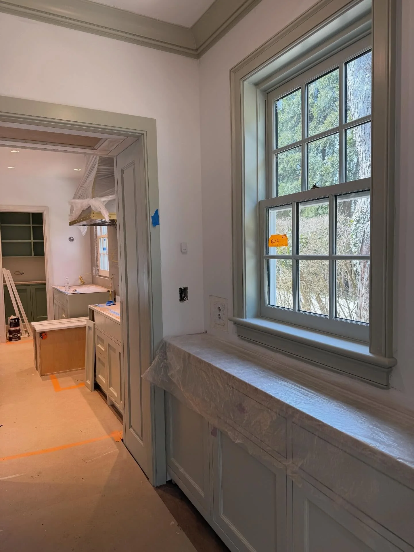 In our East Hampton house bar looking through the kitchen and into the pantry.  That bar used to be a laundry room and the pantry was once a back stairway!  Swipe for pretty dining room paint and walls awaiting wallpaper.  @kellyrosendesign #easthamp