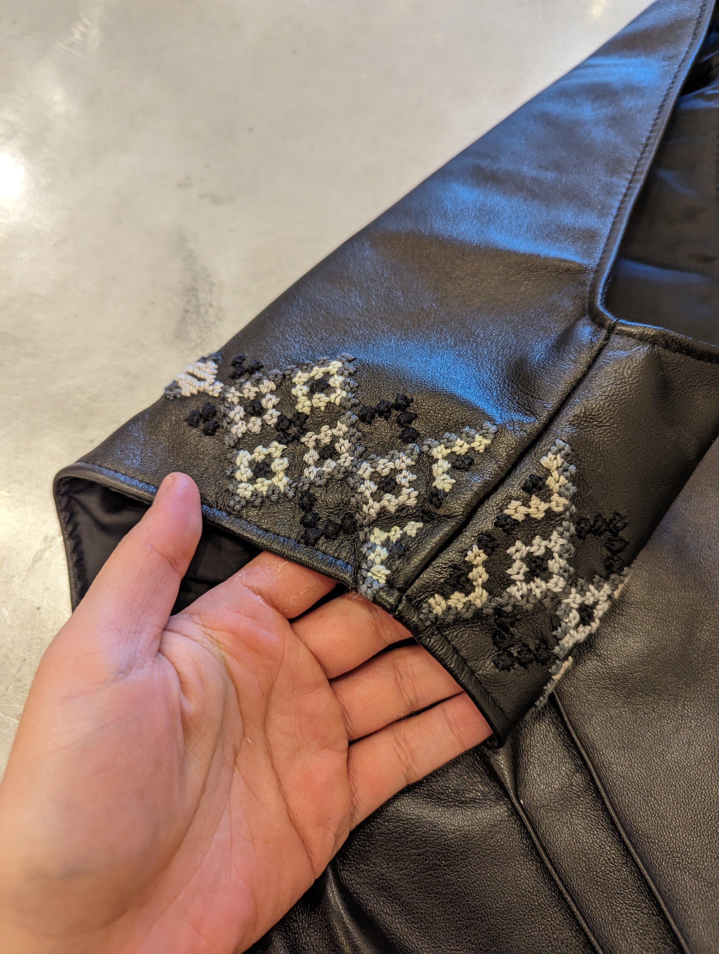 This piece is made of lamb leather, hand embroidered with Fallahi cross stitching, lined with Bemberg Cupro (sustainable) rayon, and accented with an exposed brass side zip. The piece is a size S, and fits up to a 34" chest/ 30" waist. Starting bid i