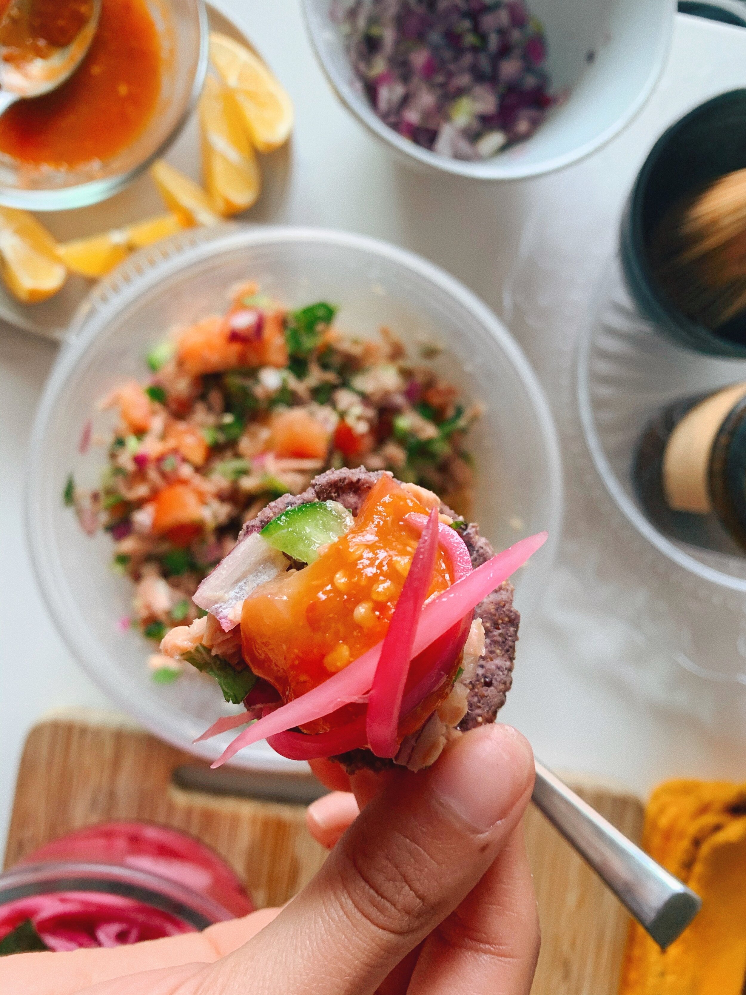 Tuna ceviche on a tortilla chip topped with pickled onions and salsa