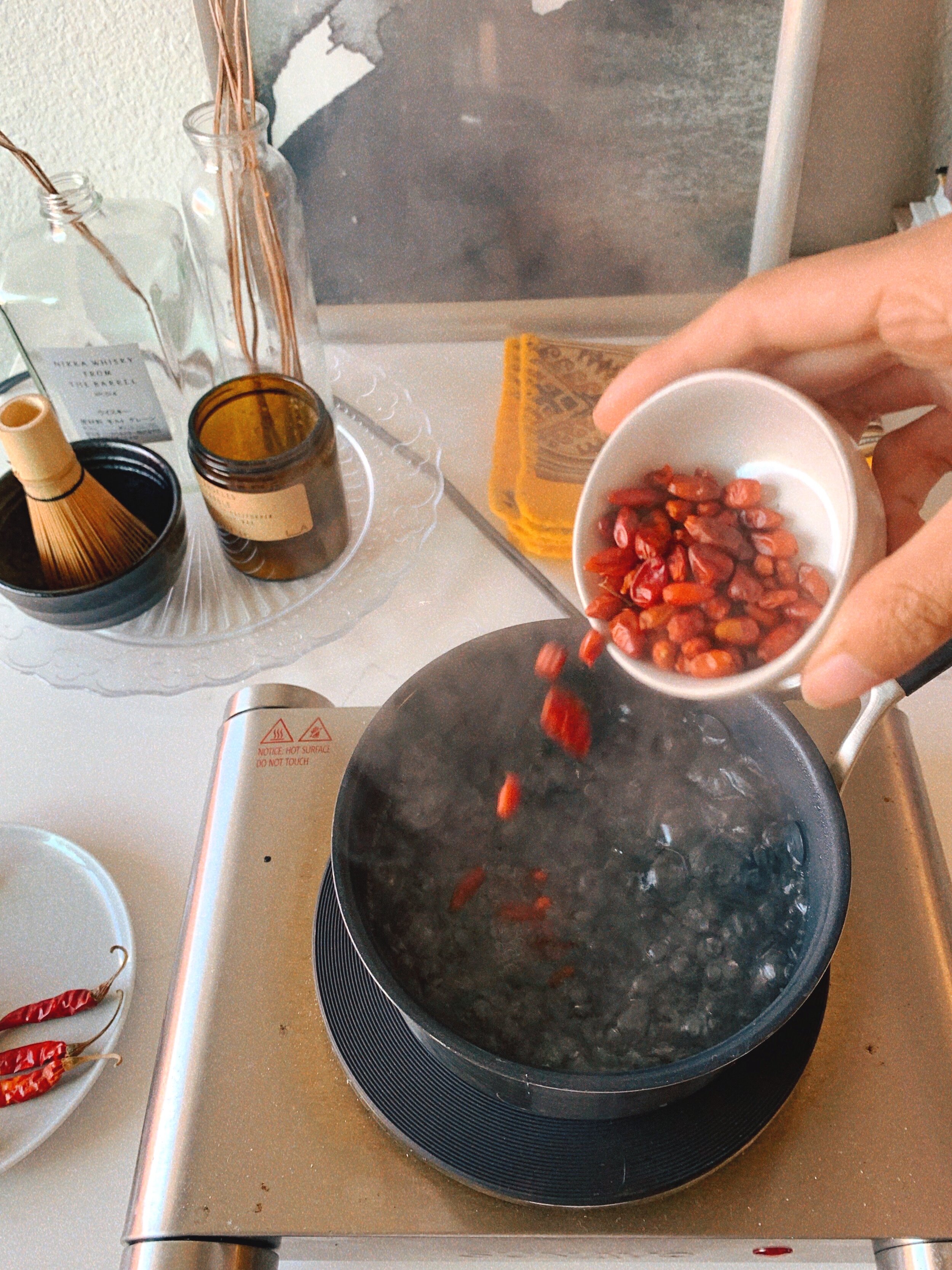 Dried chilies going into the pot of boiling water