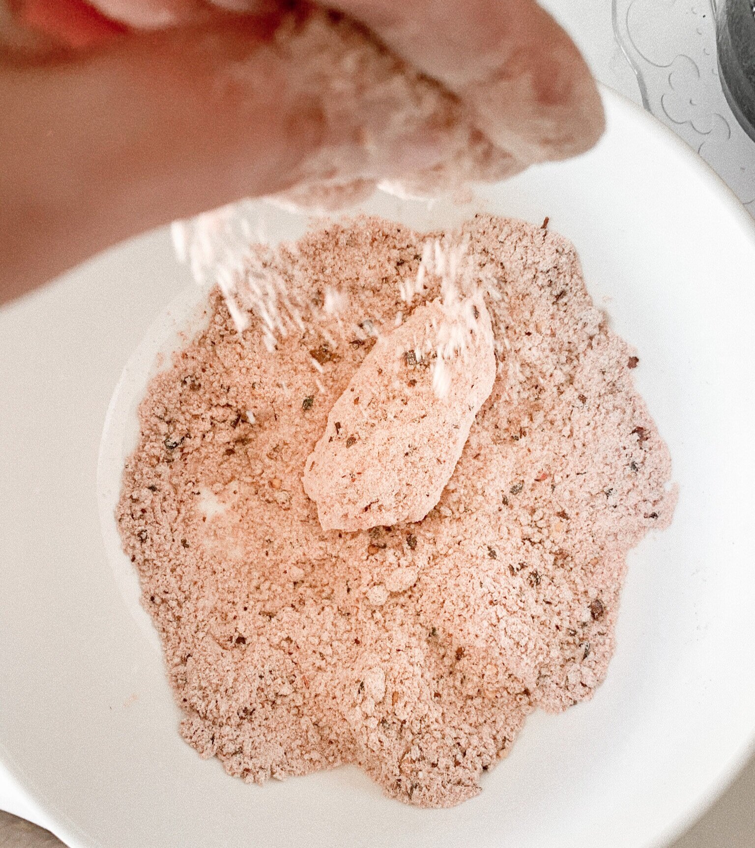 Coating each individual chicken wing in the dry mixture