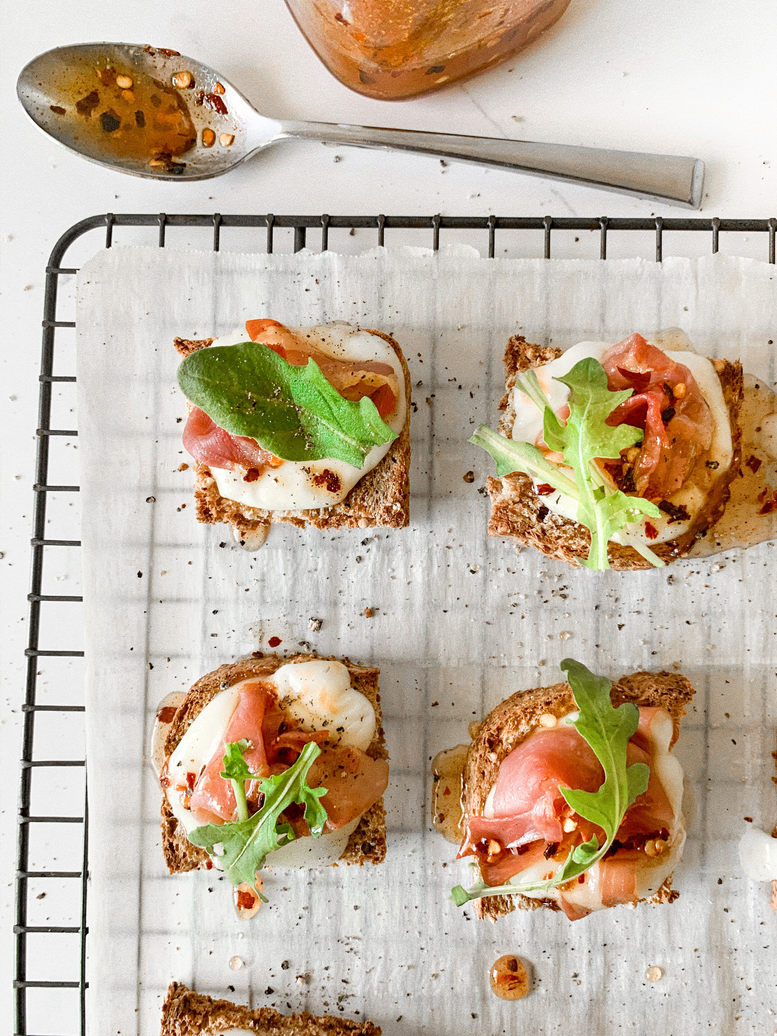 Topping off the freshly baked pizza bites with fresh arugula
