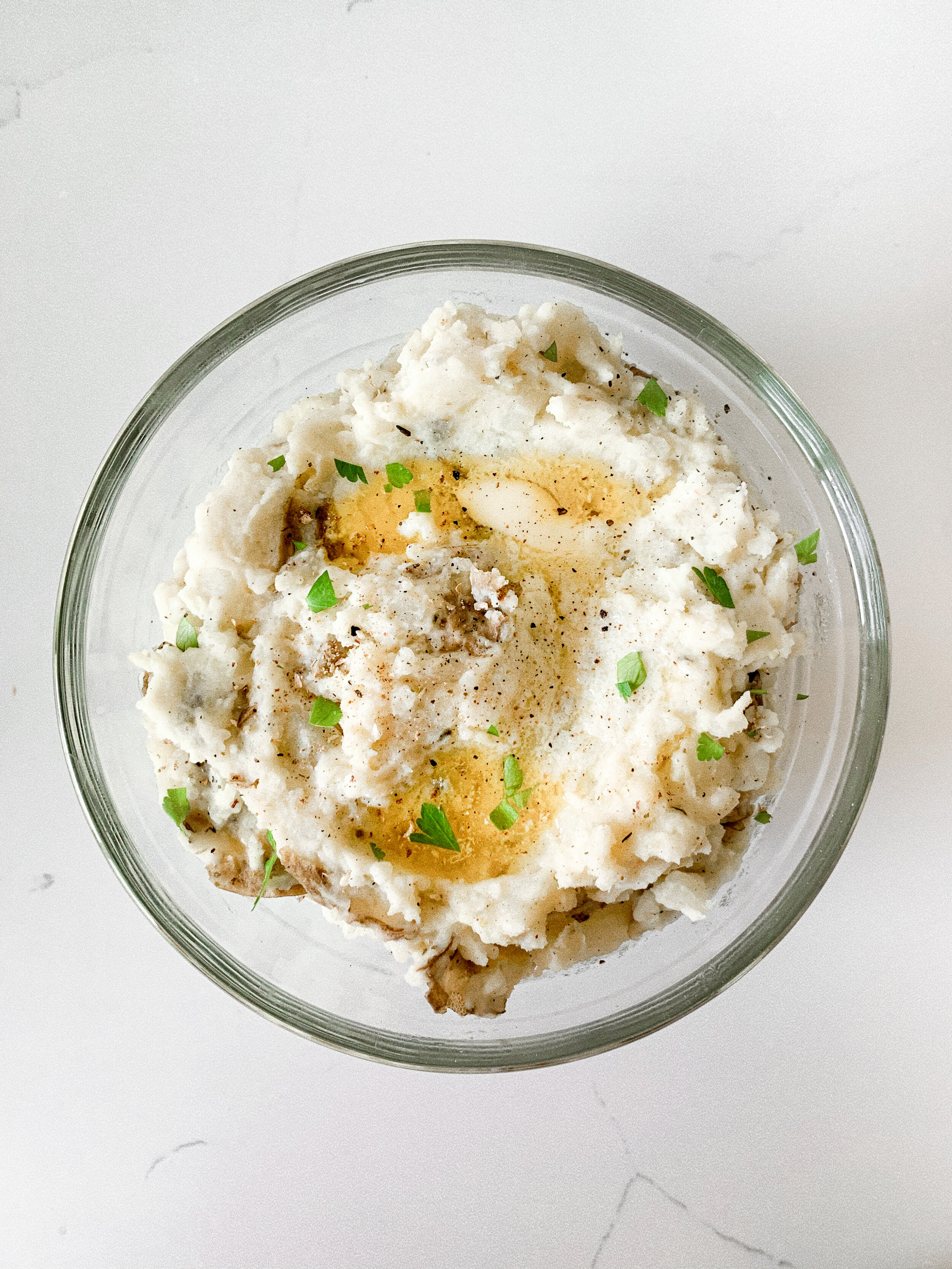 The plated 4-ingredient mashed potatoes topped with melted butter and parsley