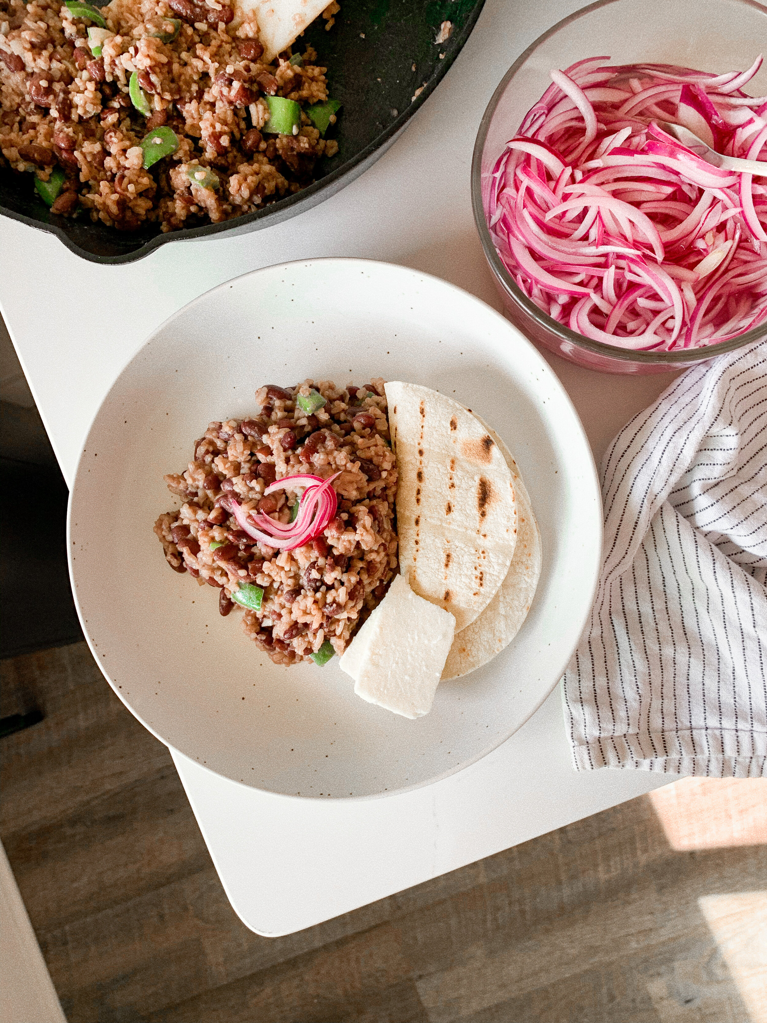 The plated casamiento with queso fresco, tortillas and pickled onions