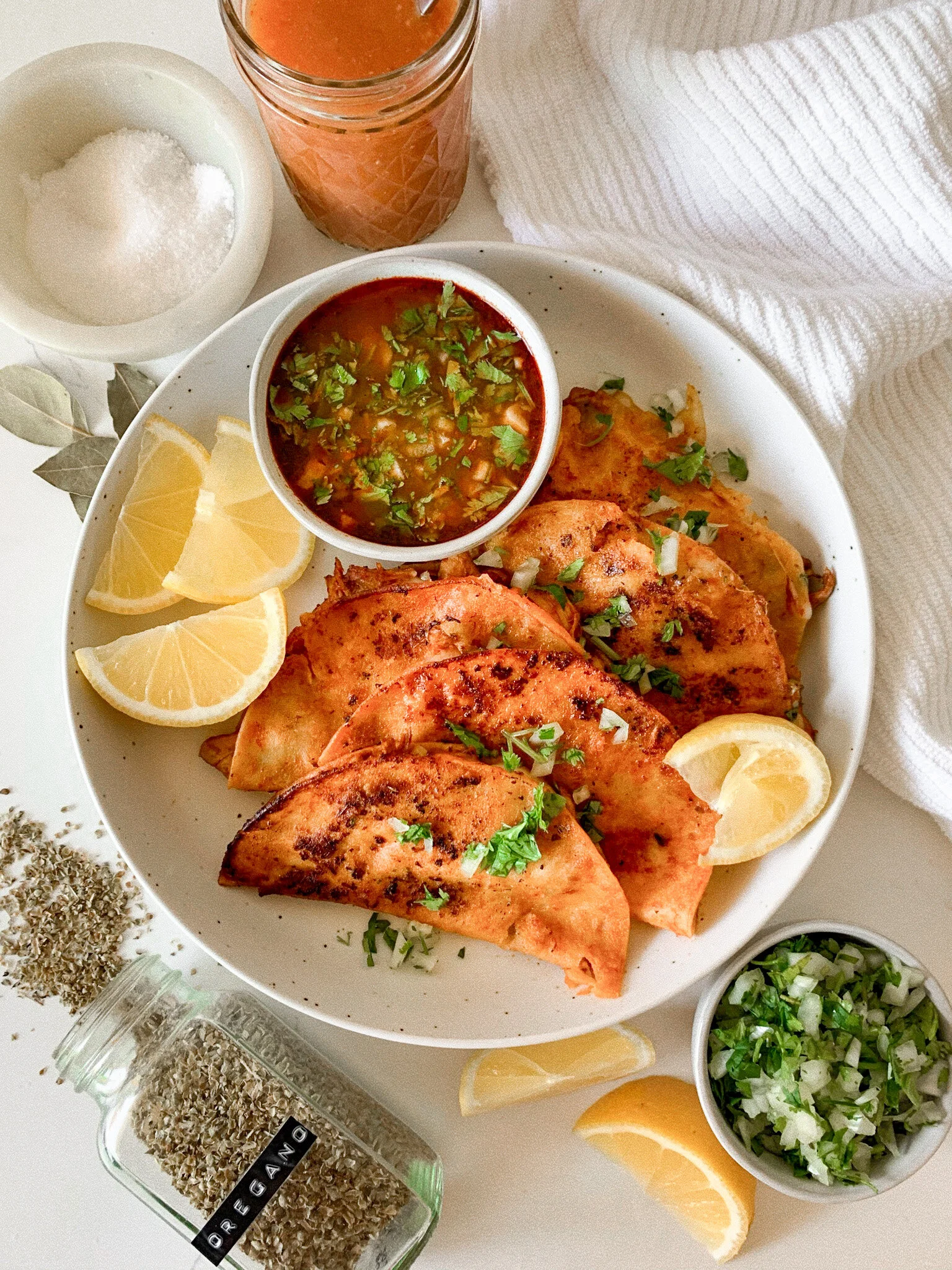 Plated chicken quesabirria tacos topped with chopped cilantro and onion