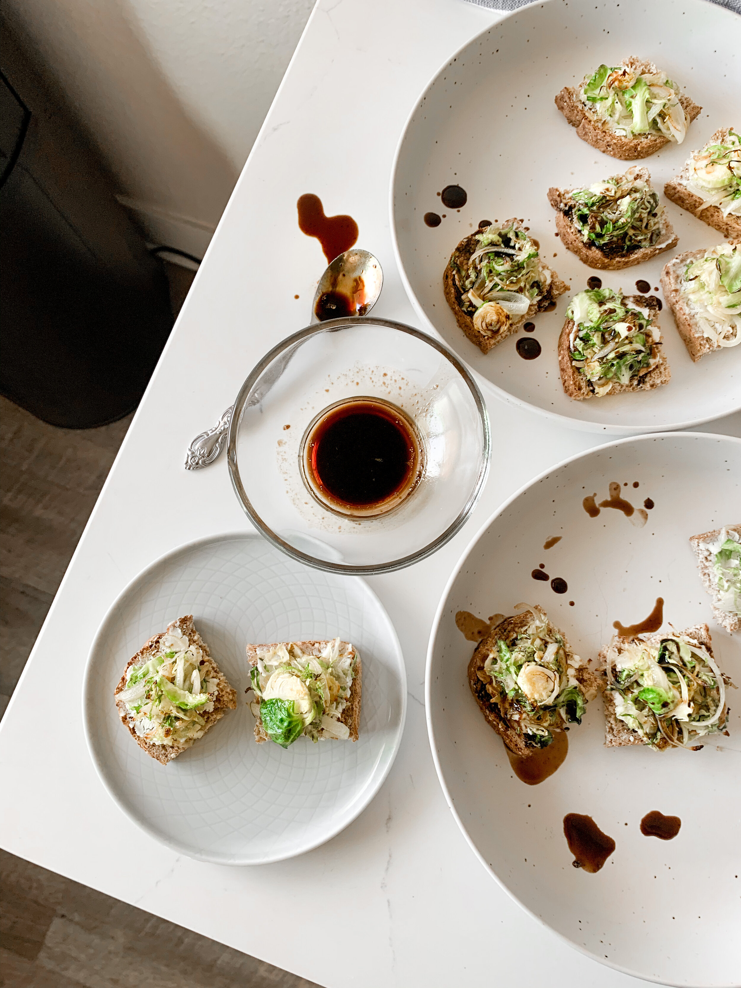 Pouring the balsamic glaze over the brussels sprout pizza bites