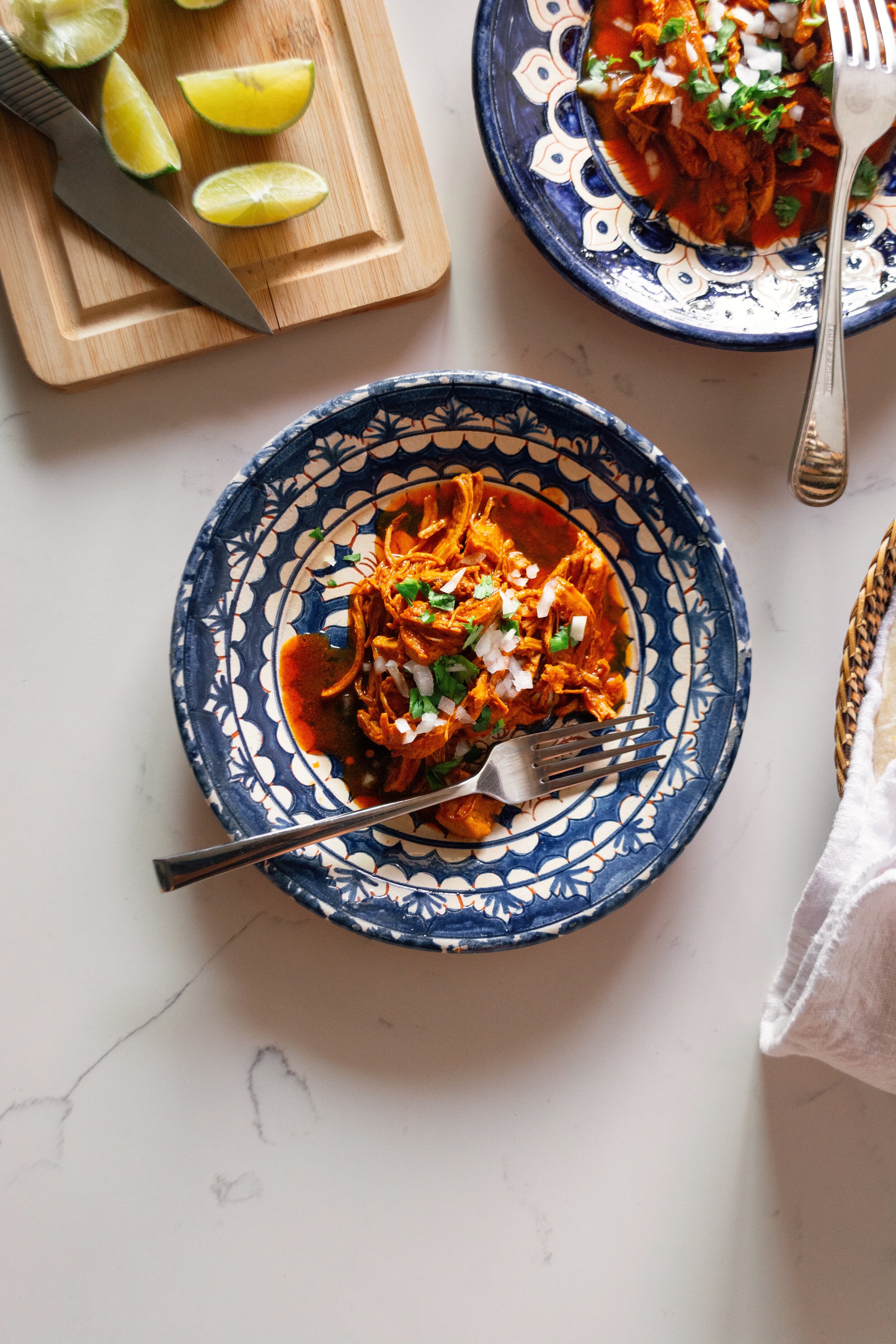 Chicken Birria (Birria de Pollo) with limes on cutting board