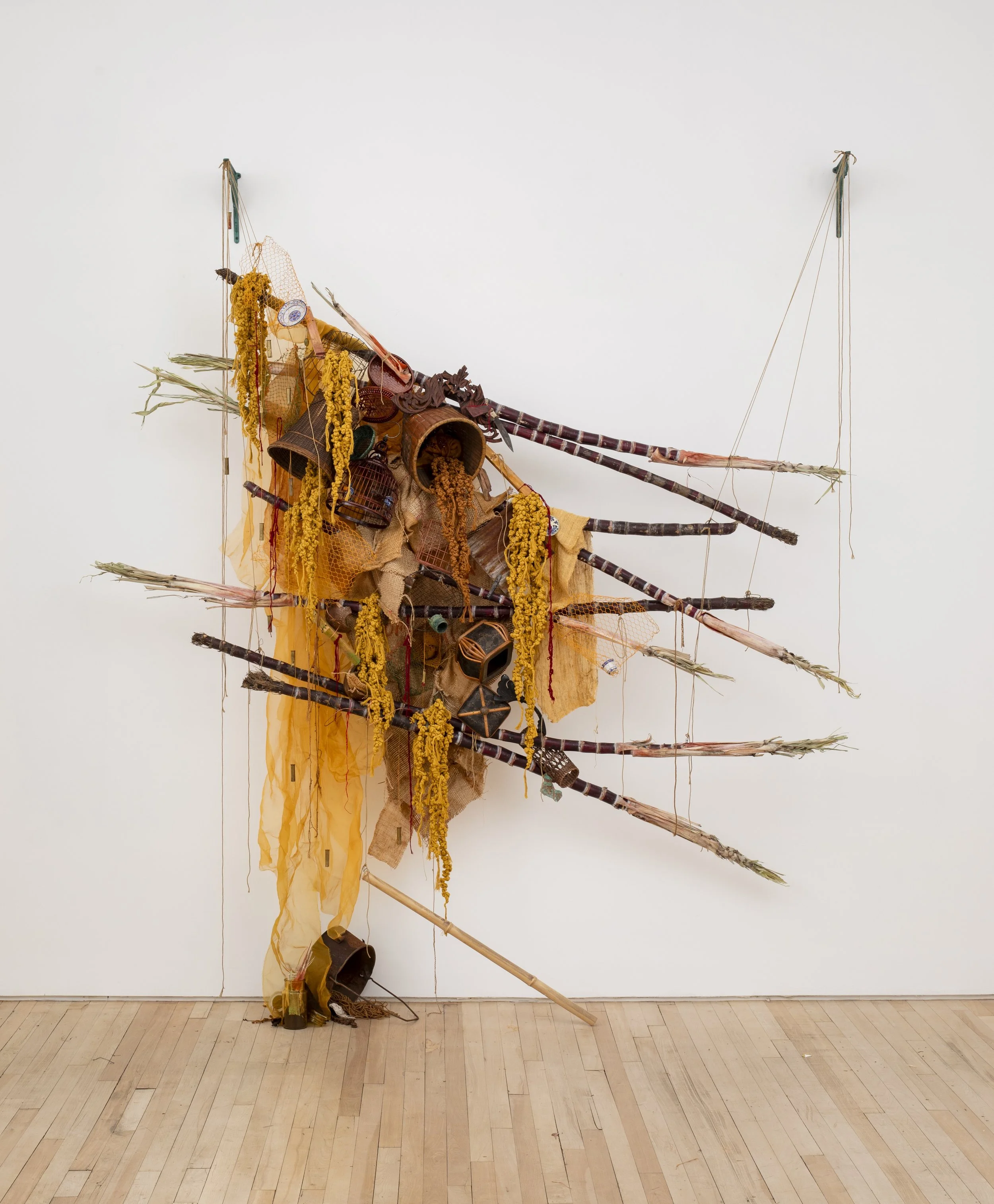 Amanda Phingbodhipakkiya,  Where sugar bleeds,   2026, Sugarcane, hand-dyed silk, woven silk, cotton cord, copper, bamboo, reclaimed vessels, porcelain, shell casings, oyster shells, thread, beads, wire, sewn coffee and grain sacks, wood, 80 x 75 x 2