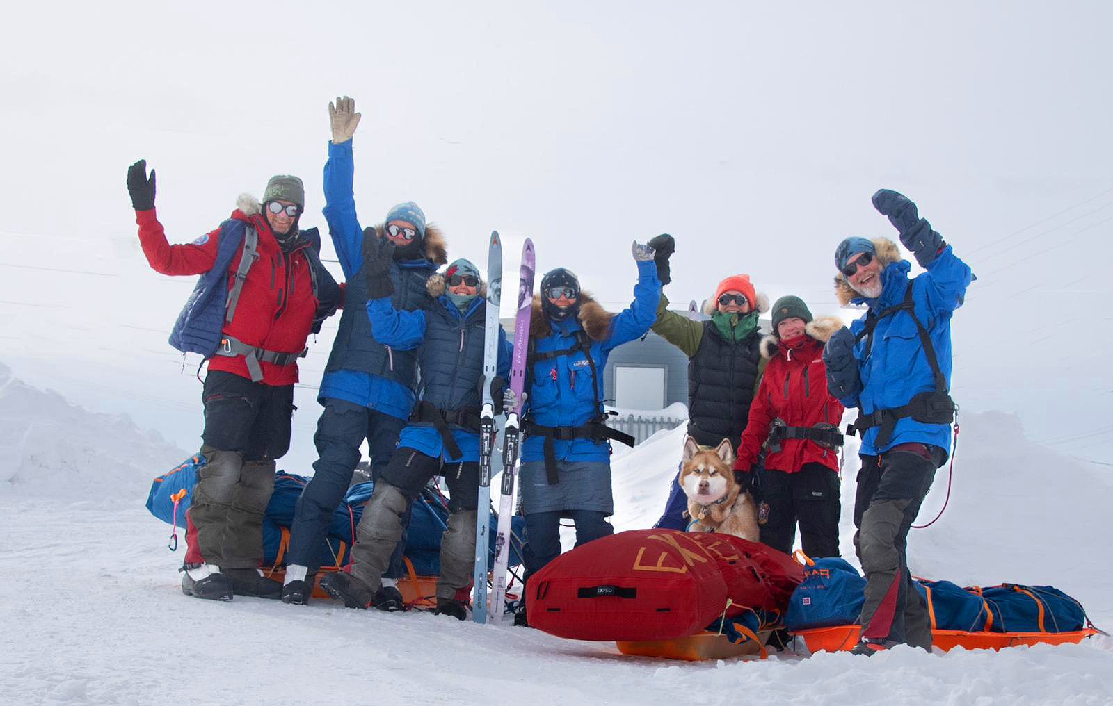 a team of polar skiers with arms raised