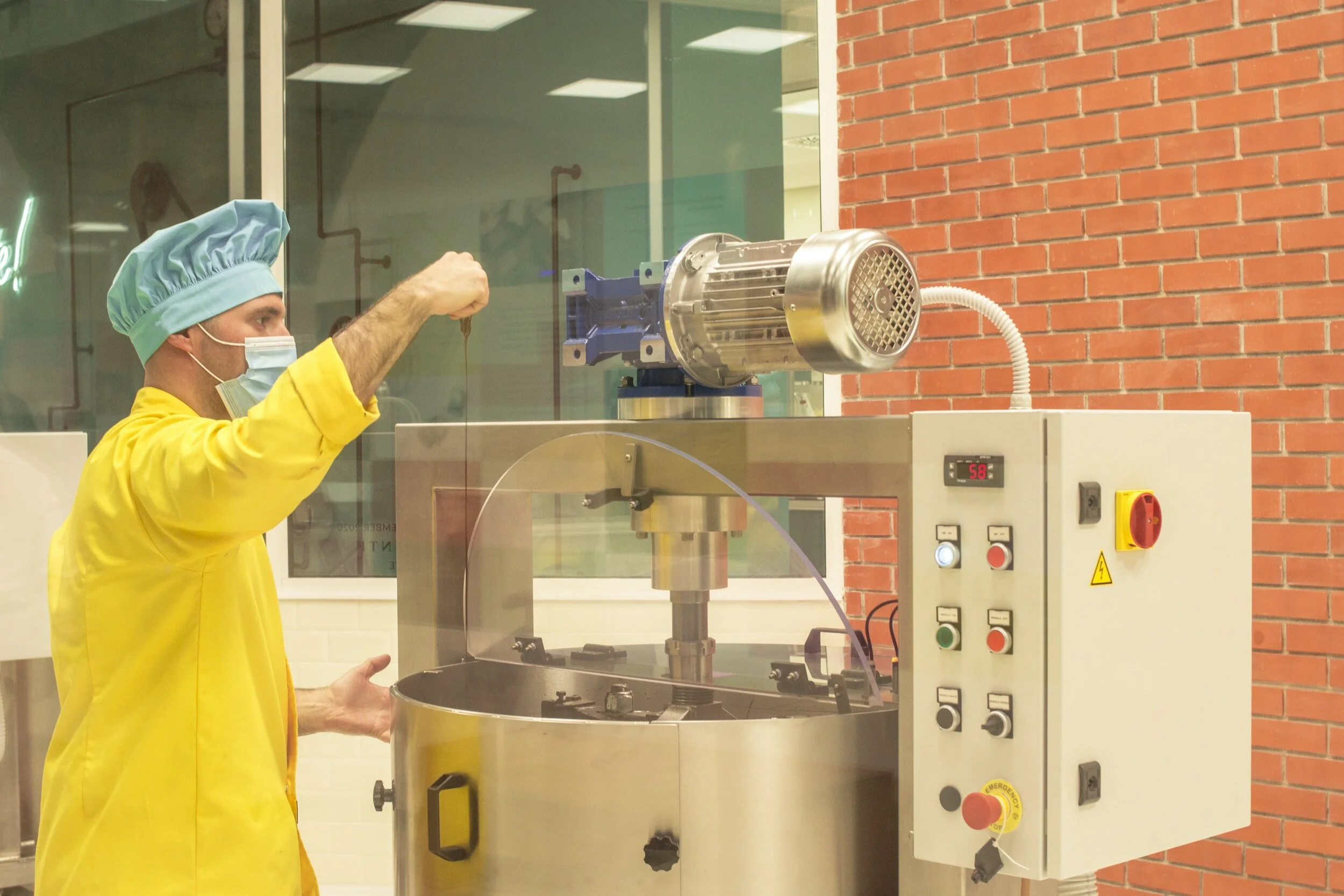 an operator manually adding ingredients to a mixer