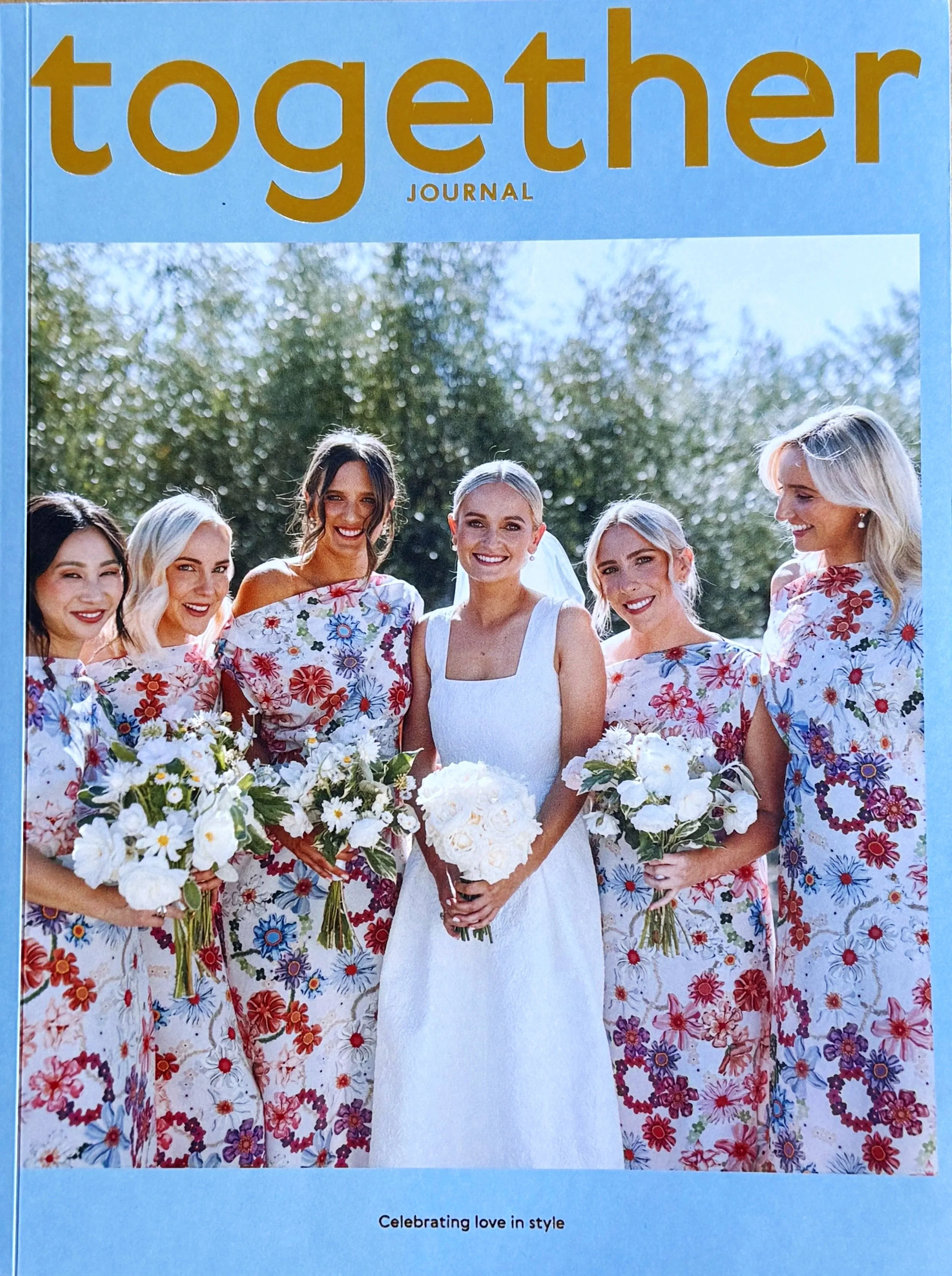 Cover of Together Journal a wedding magazine that inspires couples to celebrate their love in style. It features a real wedding of a bride and her bridesmaids holding floral bouquets.