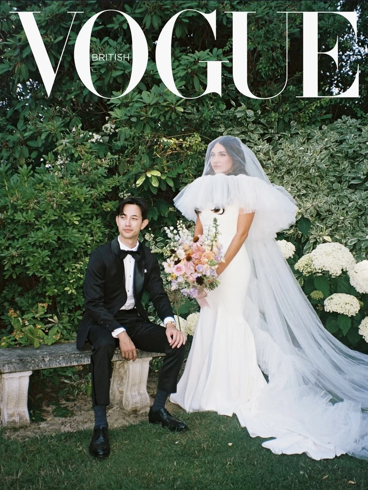 Cover of British Vogue Magazine. A bride and groom taking photos in their wedding outfits. Bride is holding a colorful pastel bouquet of PNW flowers designed by New Leaf Floral Design