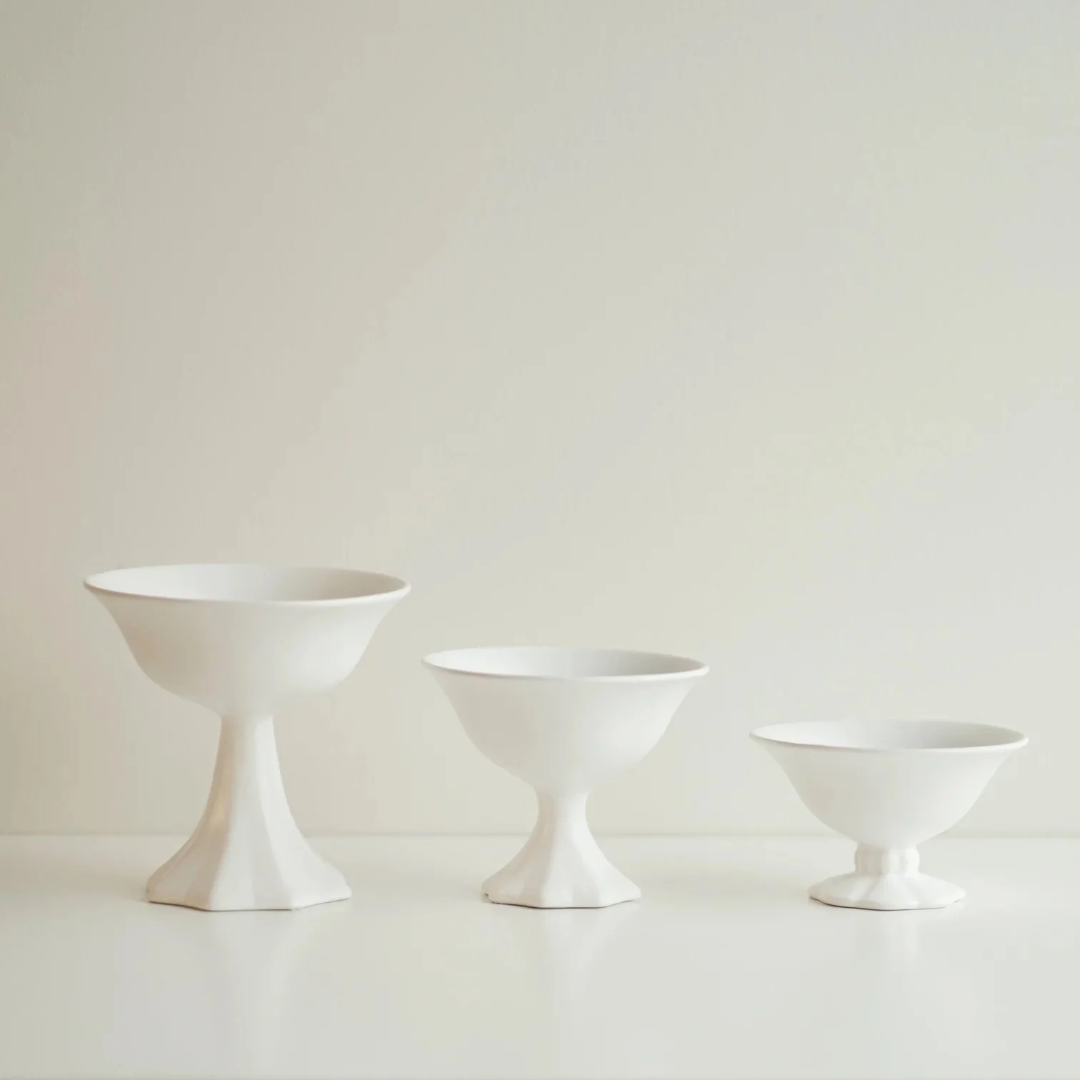 Three sizes of white ceramic vintage inspired pedestal vases.