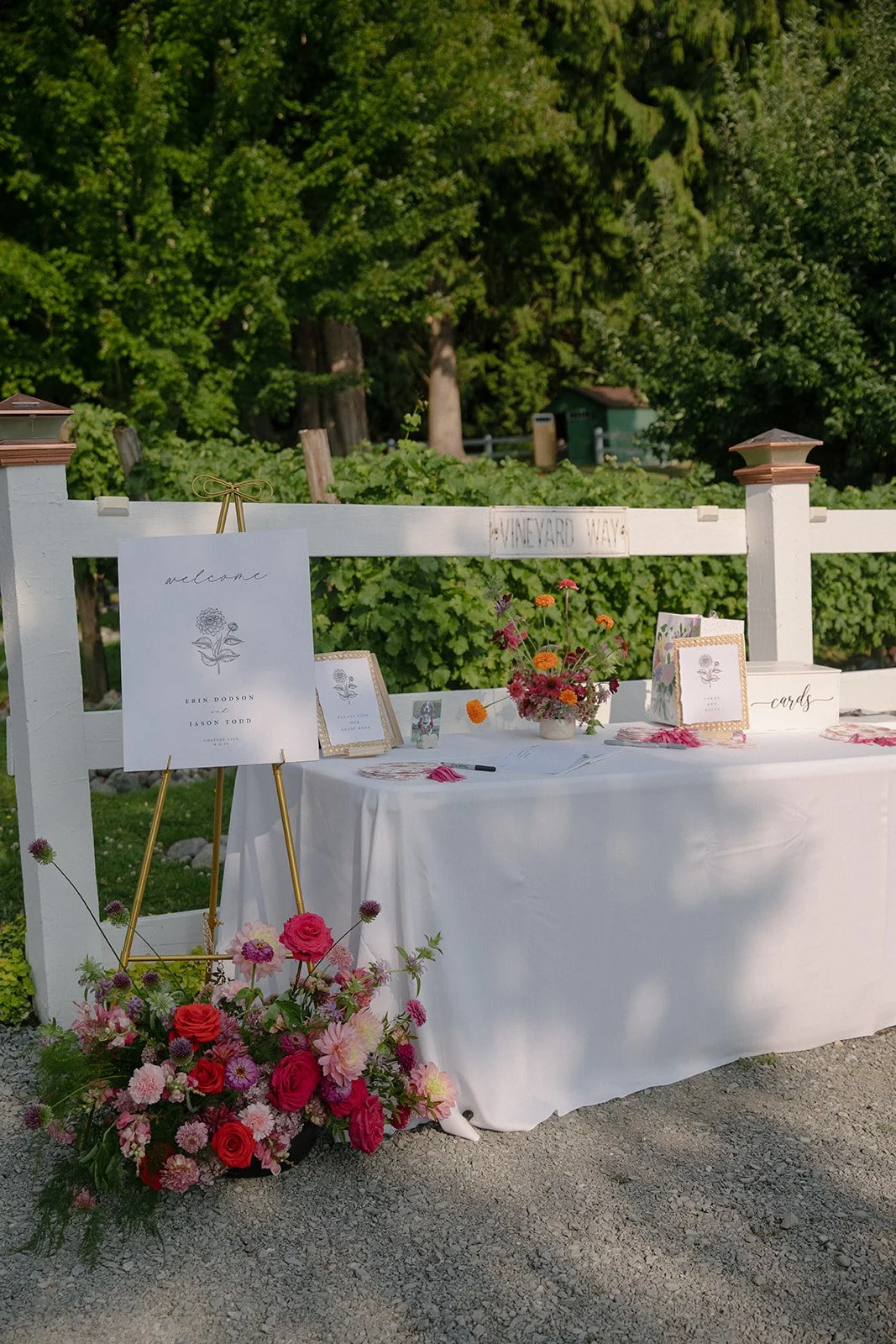 Outdoor Wedding Welcome Table with Grounded Floral Arrangement.jpeg
