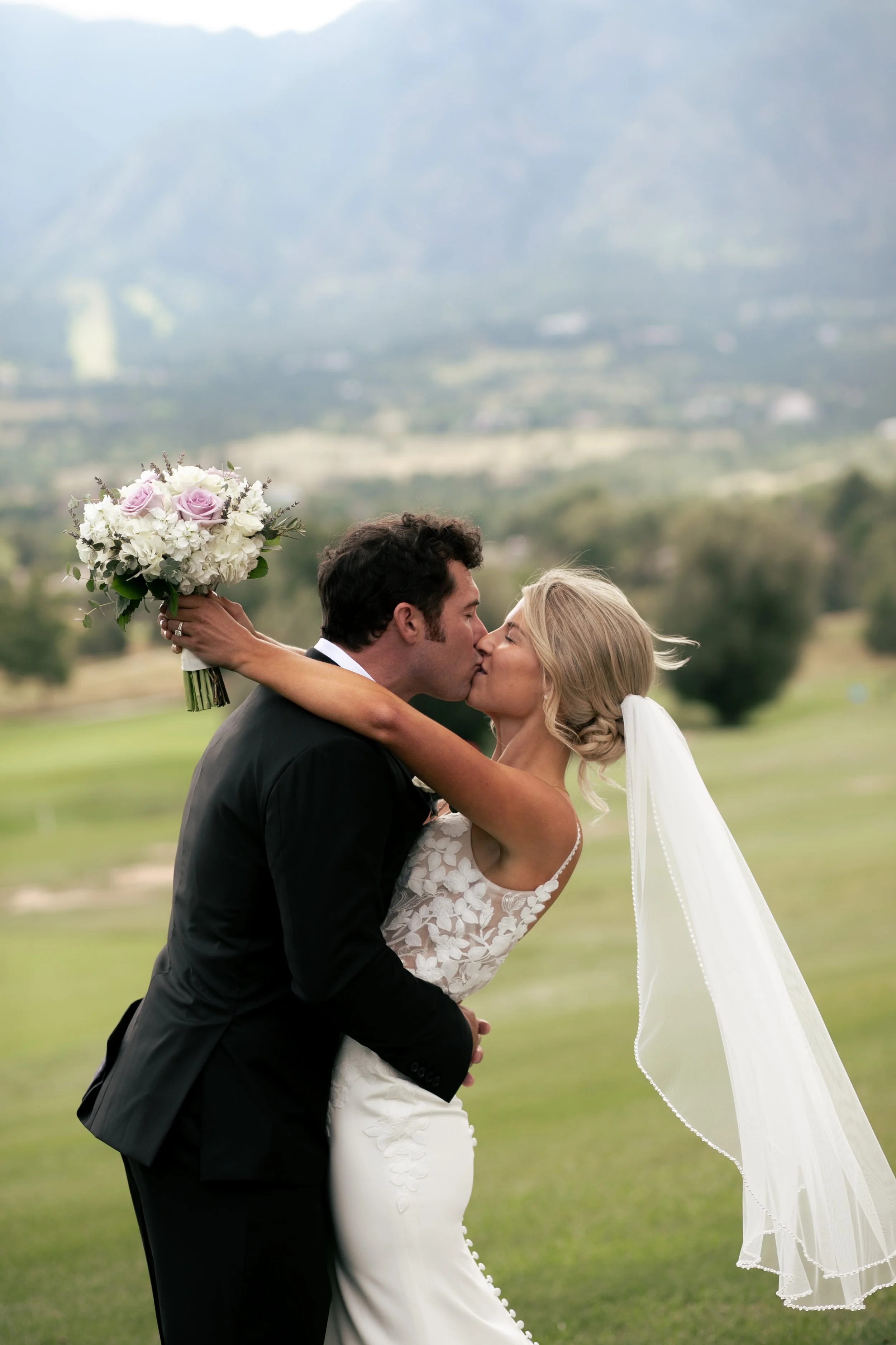 bride and groom kissing with flowers