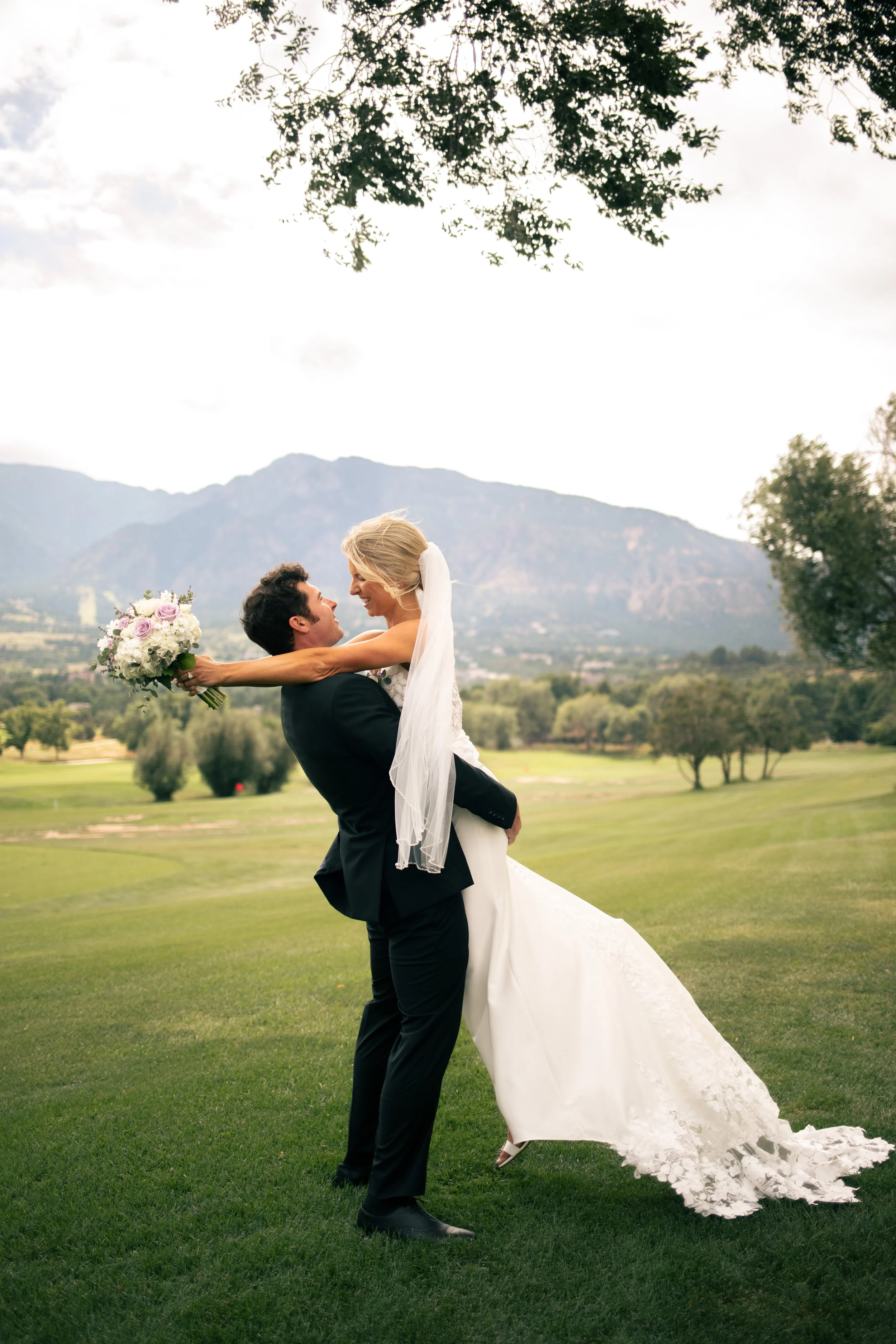 Groom picking up bride and kissing her