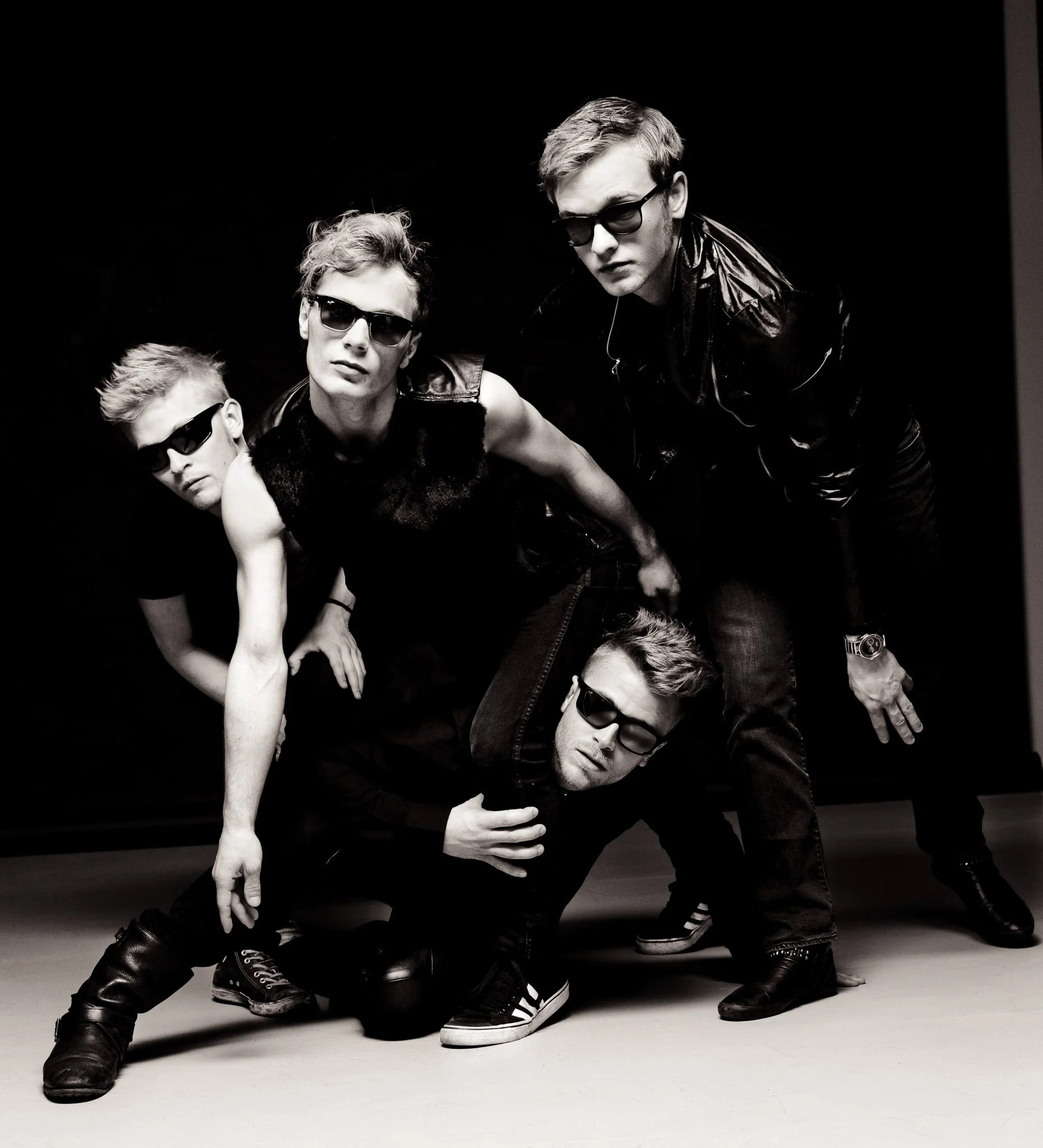 Bandfoto af A Friend In London - hårdt belyst studiefoto i sort-hvid, fore mænd i læder og med solbriller, ved Steen Brogaard.