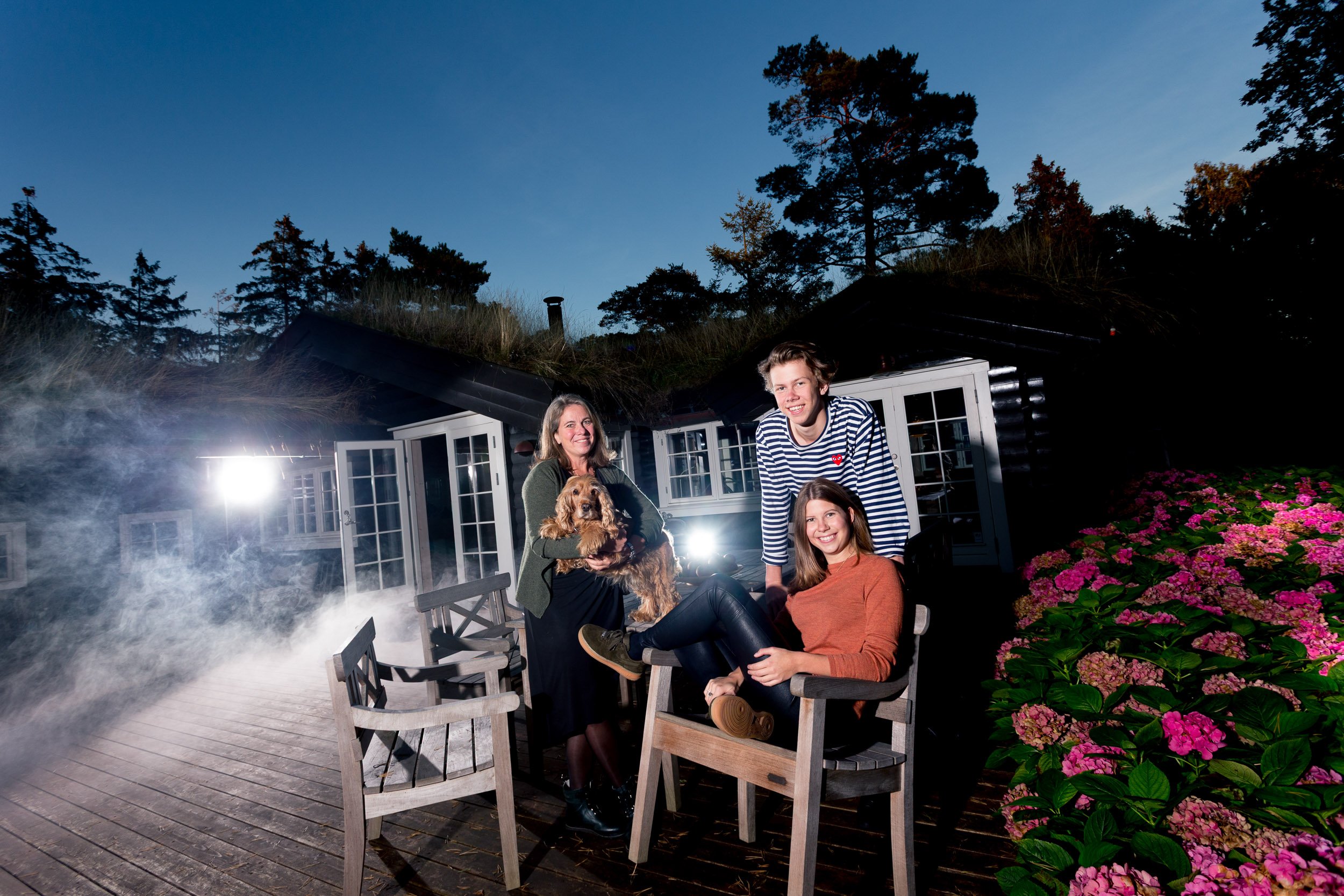 Opstillet familiebillede i sommerhus-miljø med røgmaskine, fotograf Steen Brogaard.