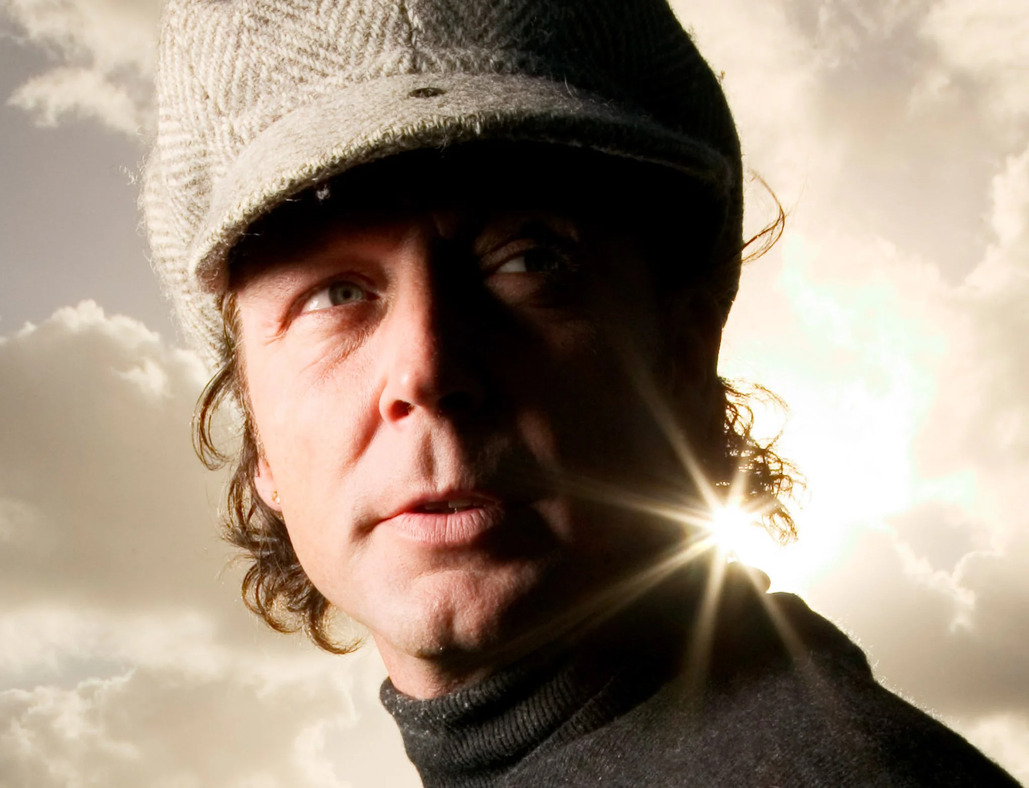 Ikonisk, dramatisk fotografi af Thomas Helmig i hårdtside, mod skyer og sol, ved Steen Brogaard.