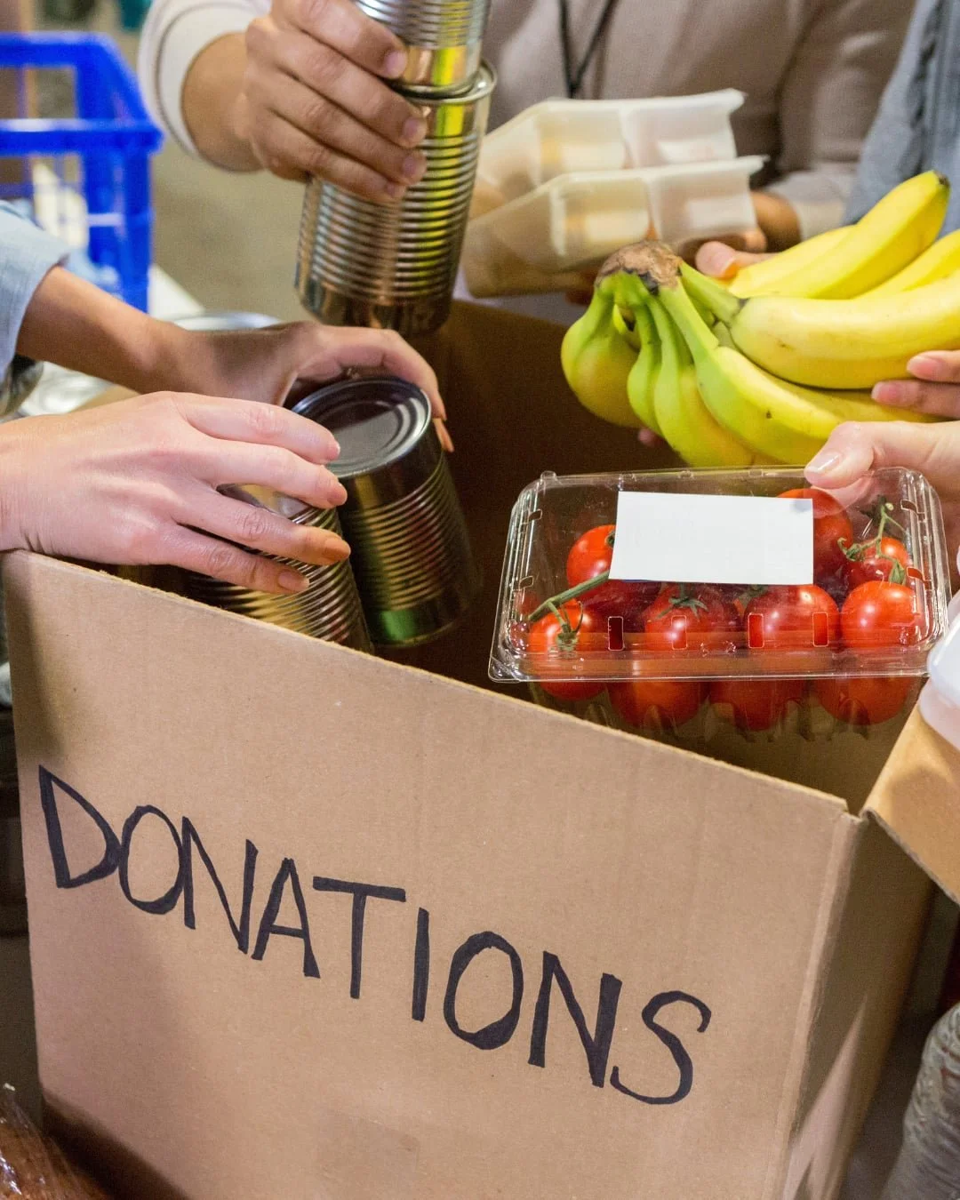 Donation box with bananas, tomatoes and tins of food