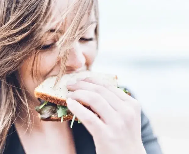 Woman eating sandwich.webp