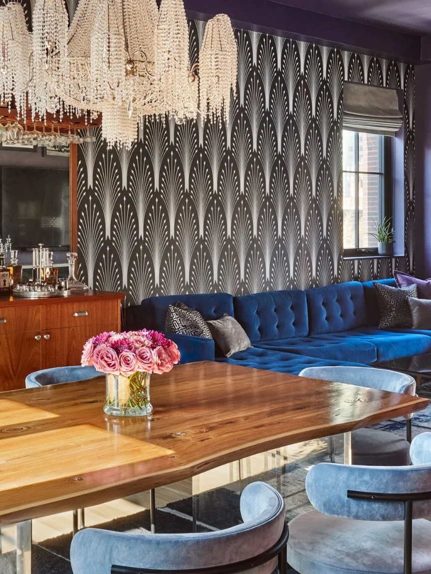 Leading into the living room.

This is where the color tension really pulls you in.

Once you move through the fuchsia entry hall, the apartment opens into the living, dining, and kitchen planned as one continuous entertainment space.

The living roo