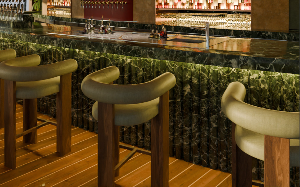 Cocktail bar with a dark green marble counter, light green leather bar chairs, wooden yacht-style flooring and a backlit display of spirits and cocktail glassware. Bar designed by Studio Numen for a beach club in Bali.