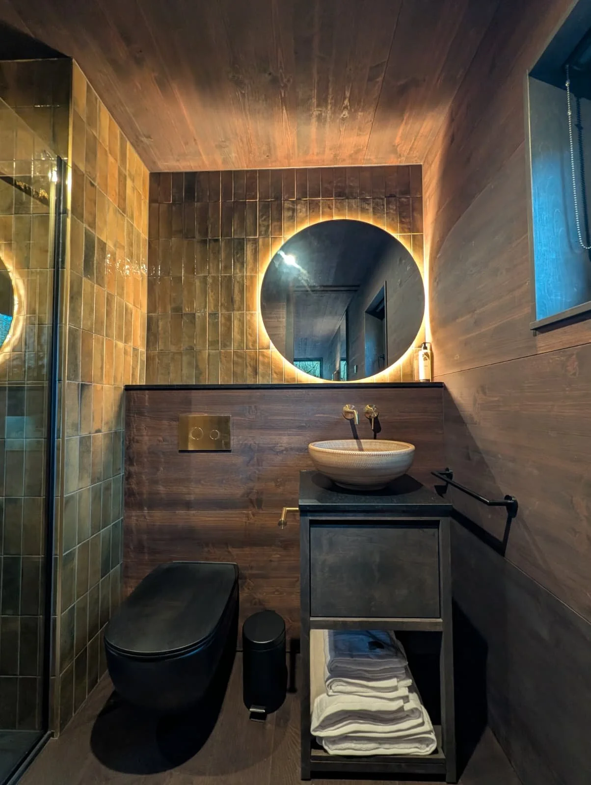 This is an image of a luxury cabin interior with stunning tiles and mood lighting with an LED mirror