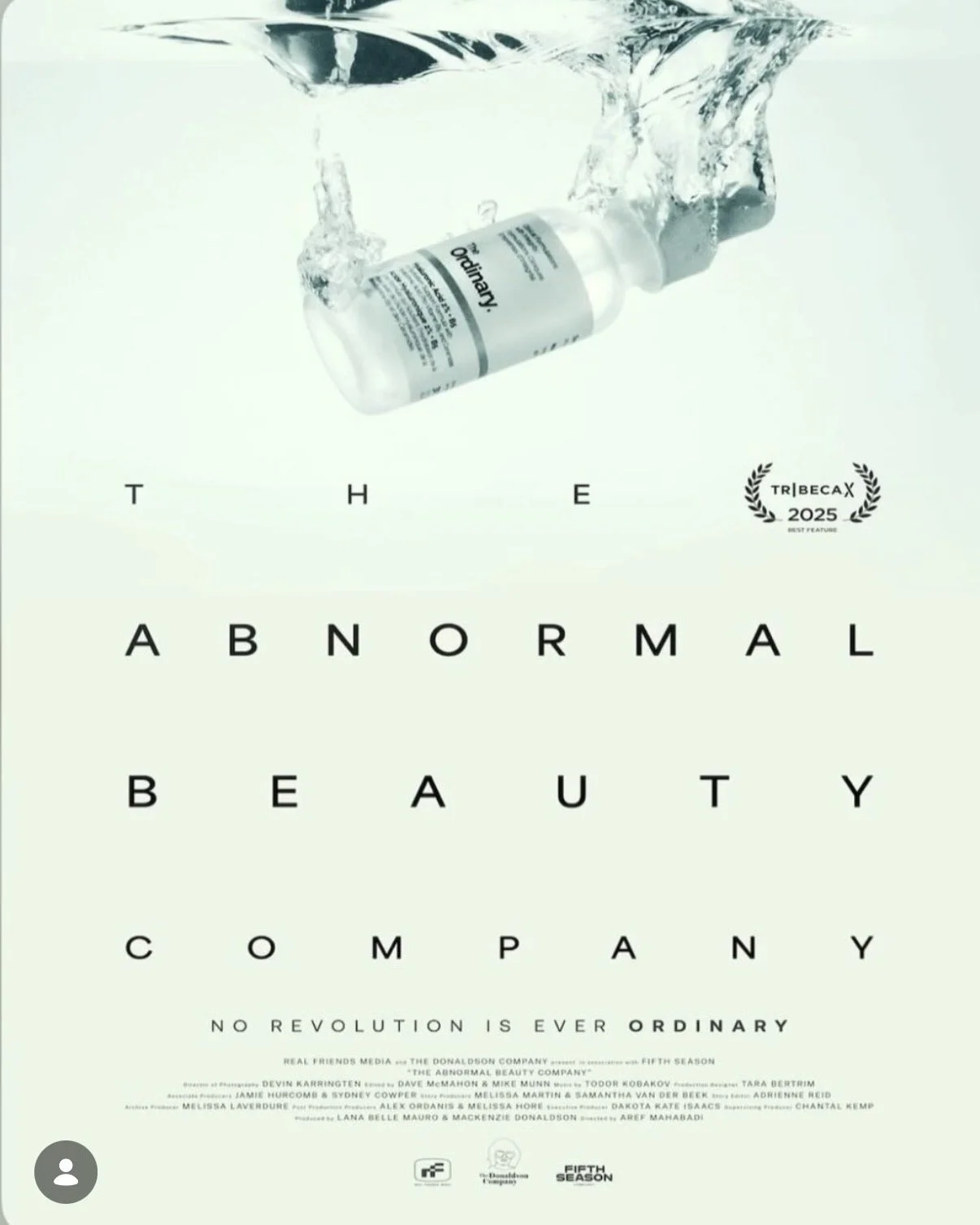 A pharmaceutical bottle with water splashing around it, on a white background. Below, the words spell out "THE ABNORMAL BEAUTY COMPANY" with the slogan "No revolution is ever ordinary" underneath. There is a small award badge indicating a 2025 Tribeca Best Feature award.