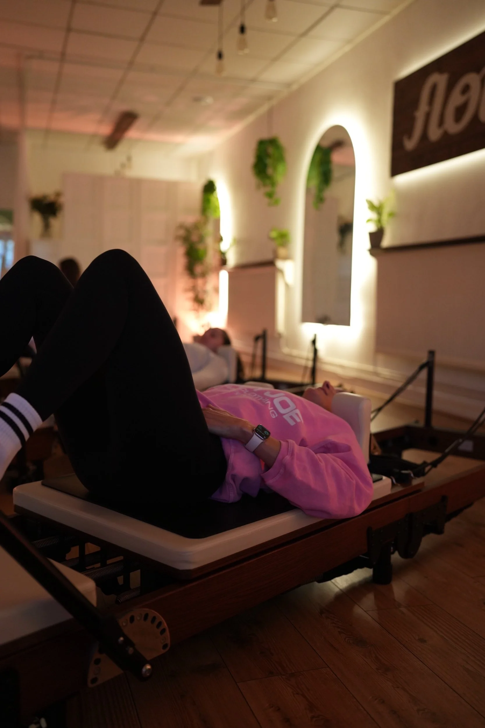 lady with knees bent on a Pilates reformer