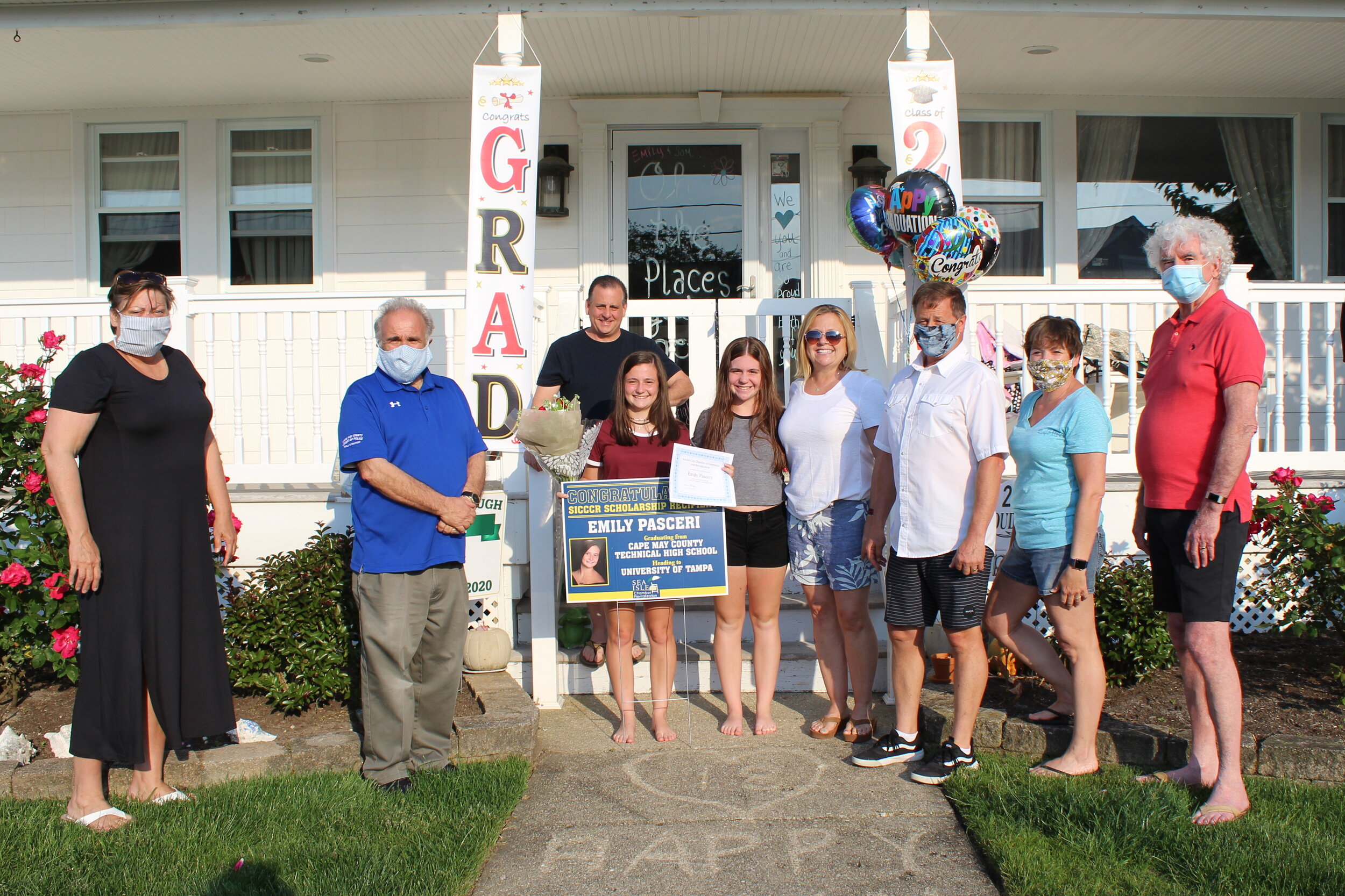  SICCCR scholarship recipient Emily Pasceri, joined by her parents and sister in front of her family’s home, poses with the sign and certificate that were presented by the mayor and Chamber representatives. 